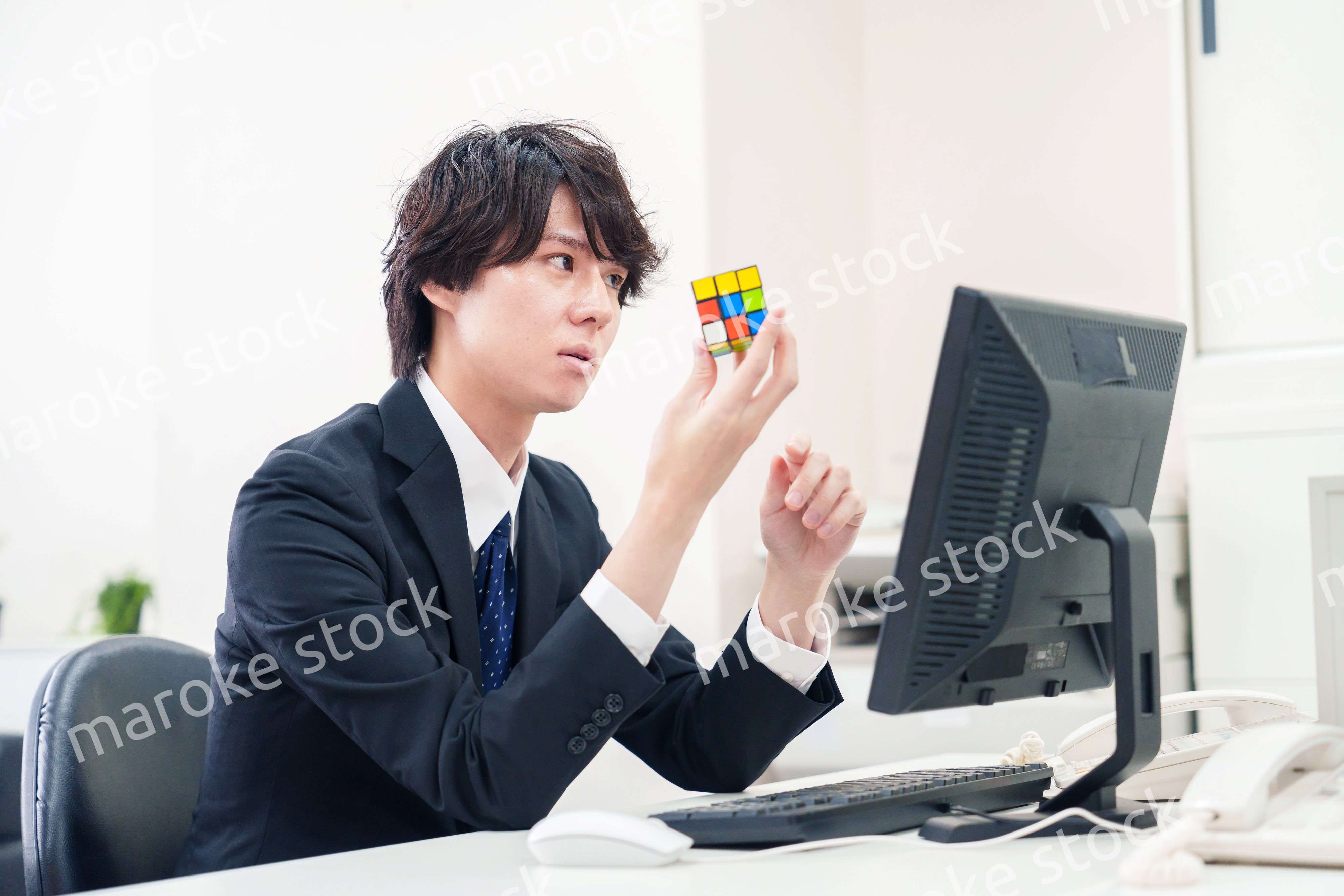 仕事中にルービックキューブをするビジネスマン