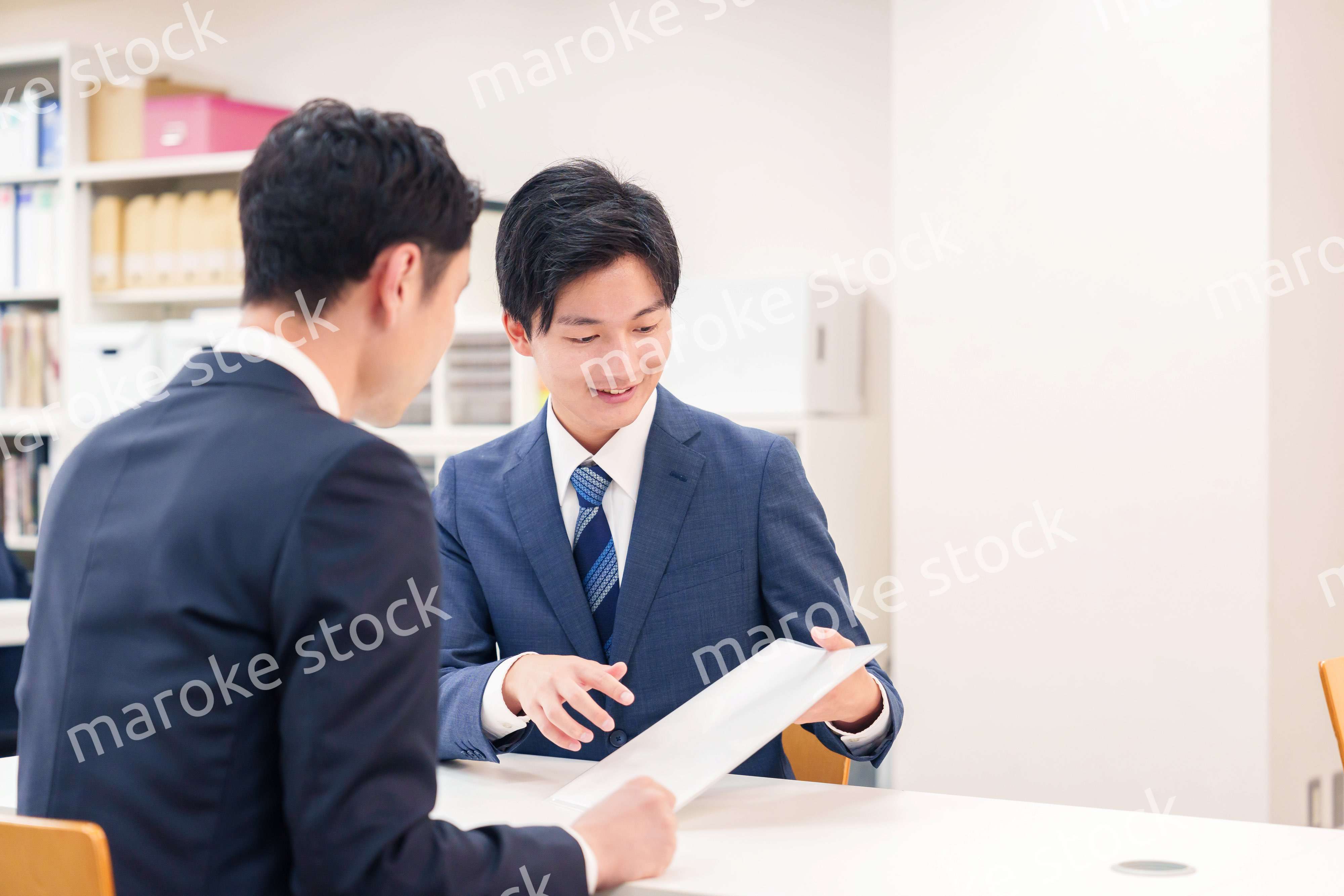 窓口で来客の対応をするビジネスマン