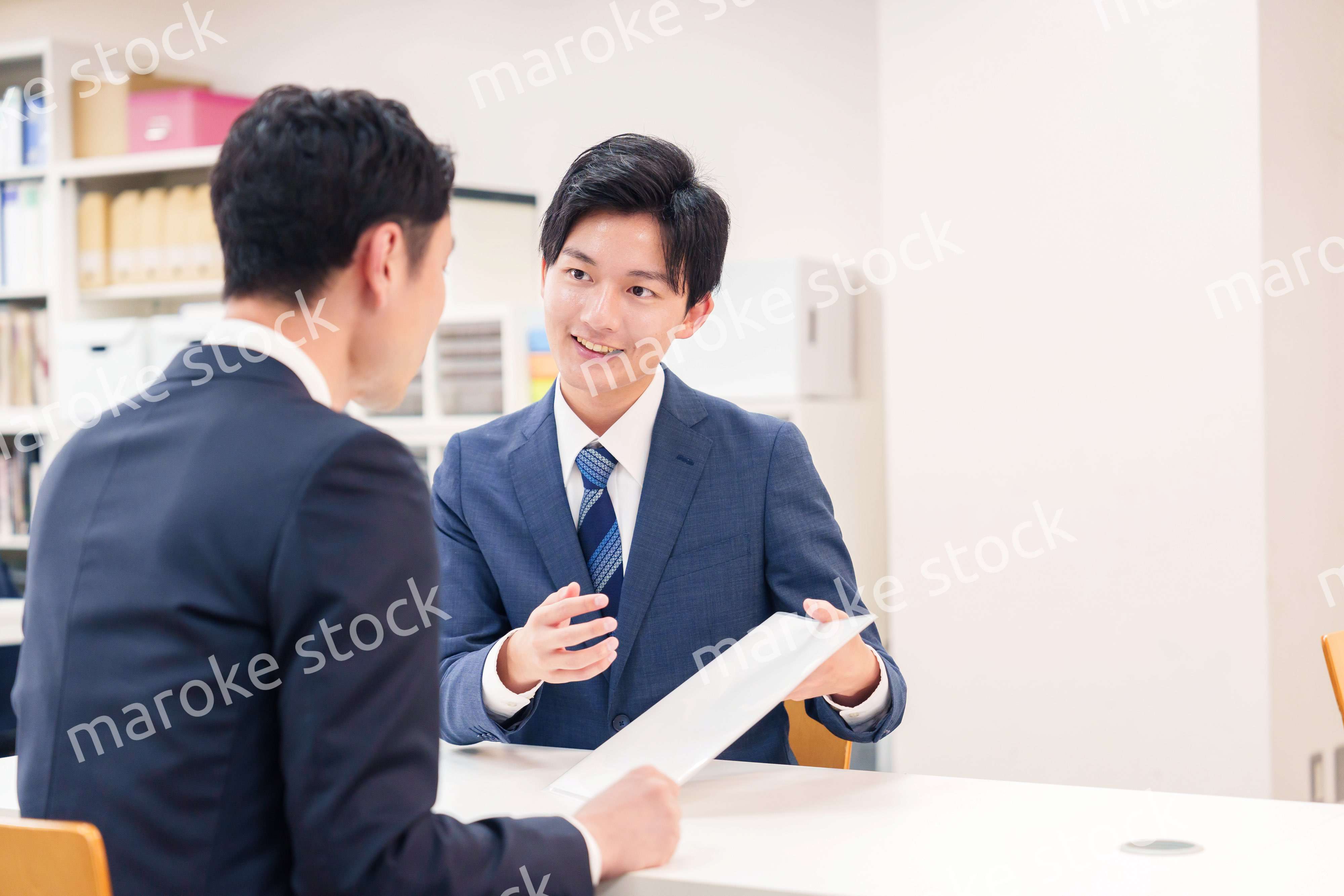 窓口で来客の対応をするビジネスマン