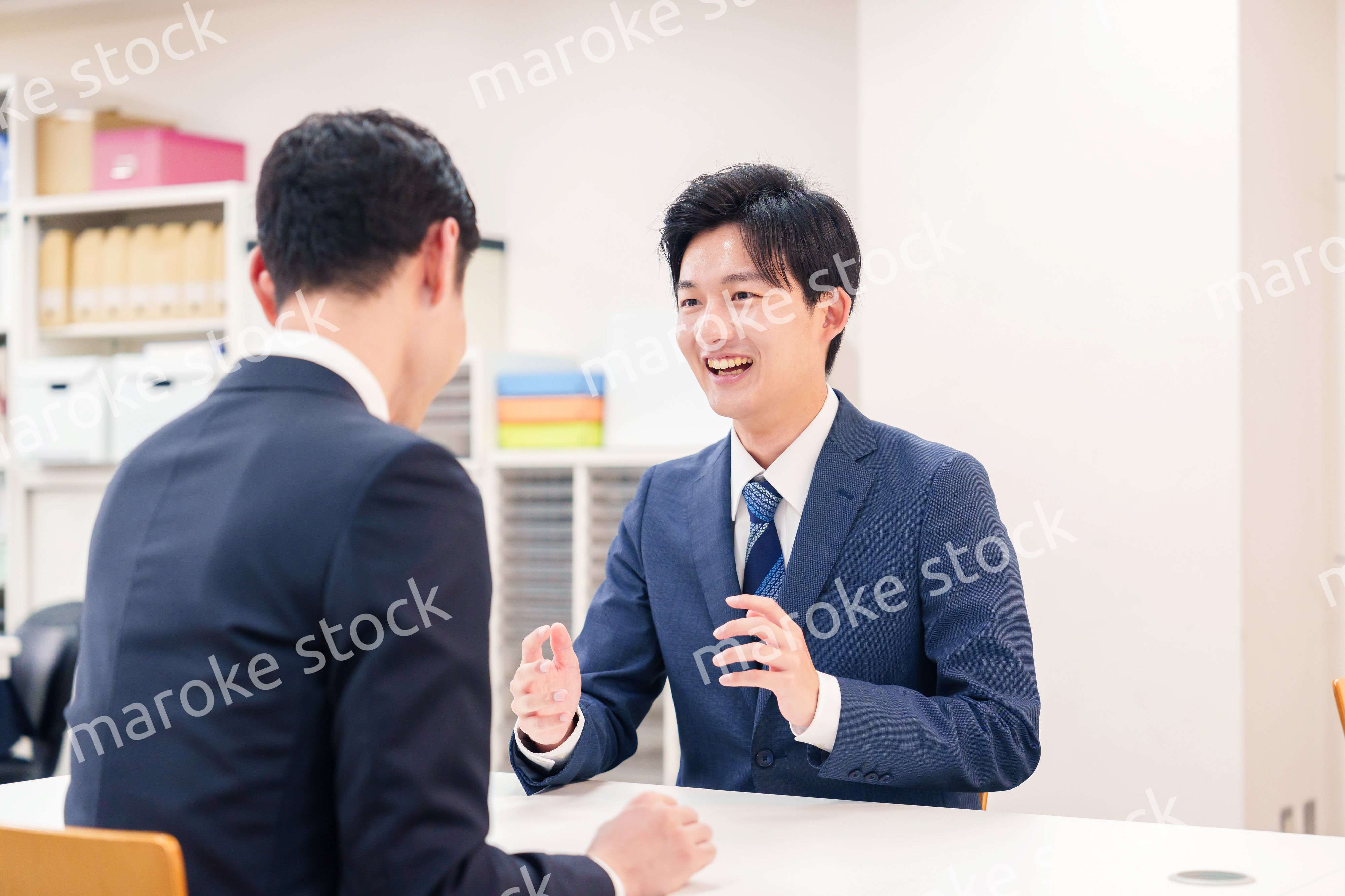 窓口で来客の対応をするビジネスマン