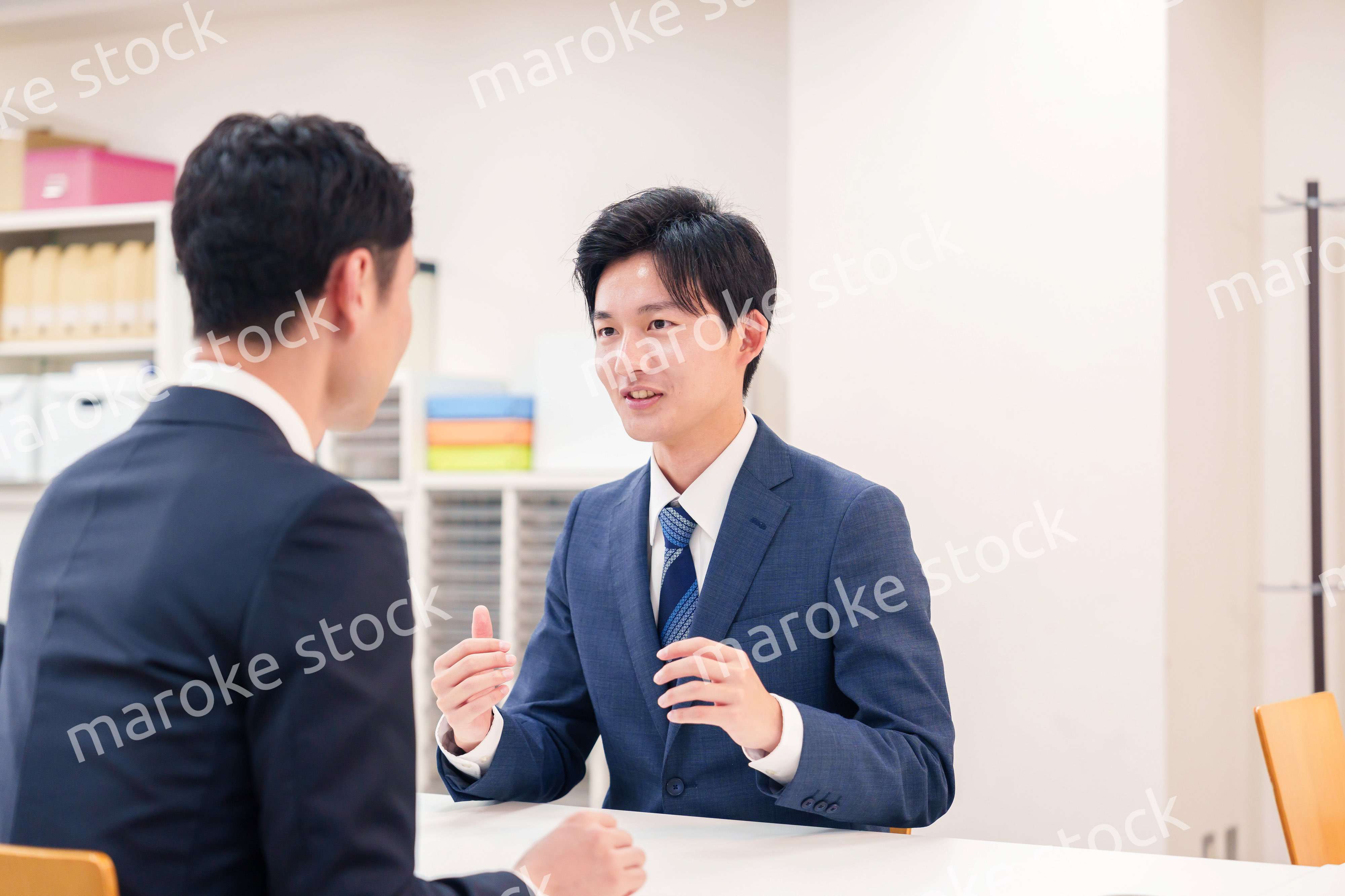 窓口で来客の対応をするビジネスマン