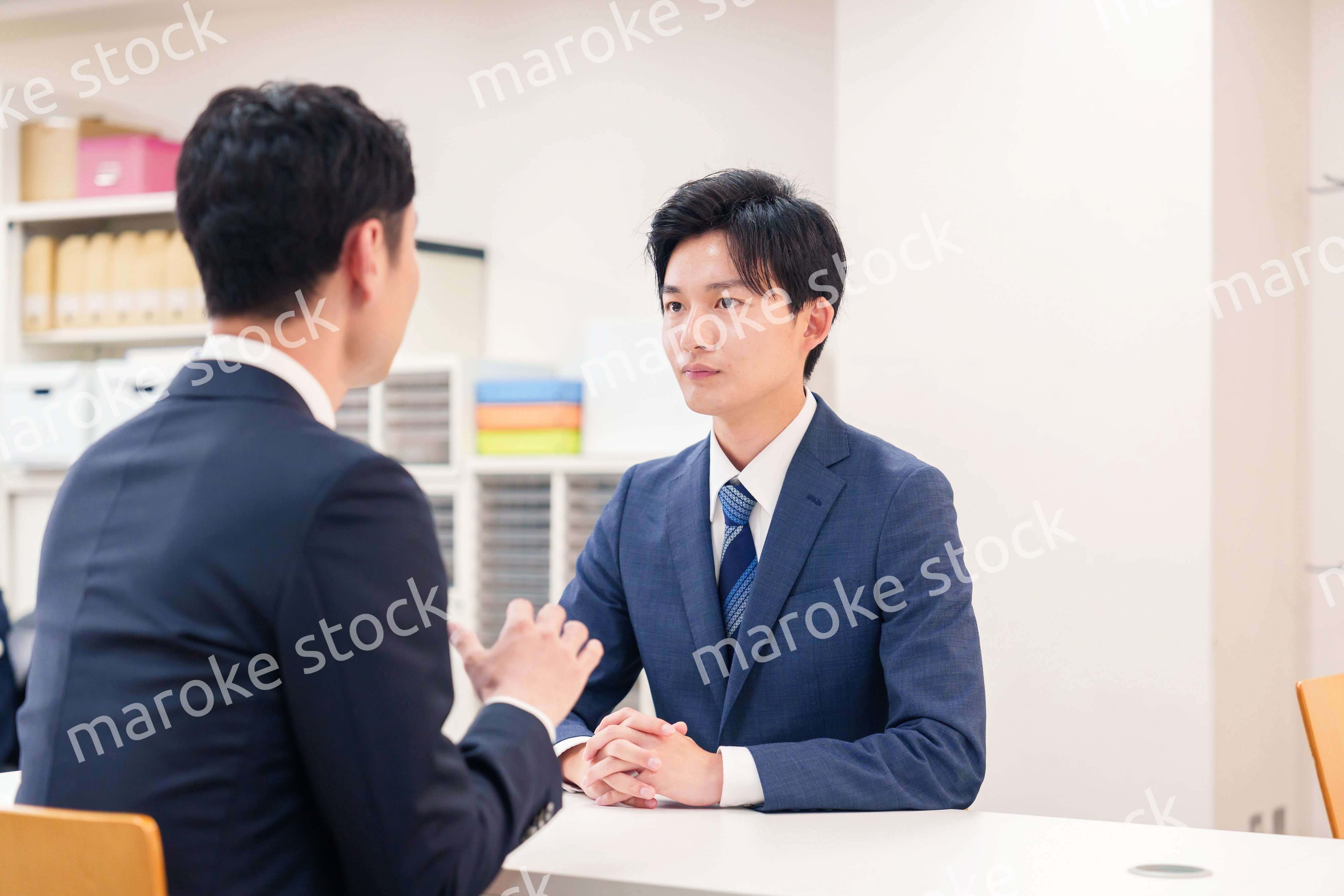 窓口で来客の対応をするビジネスマン