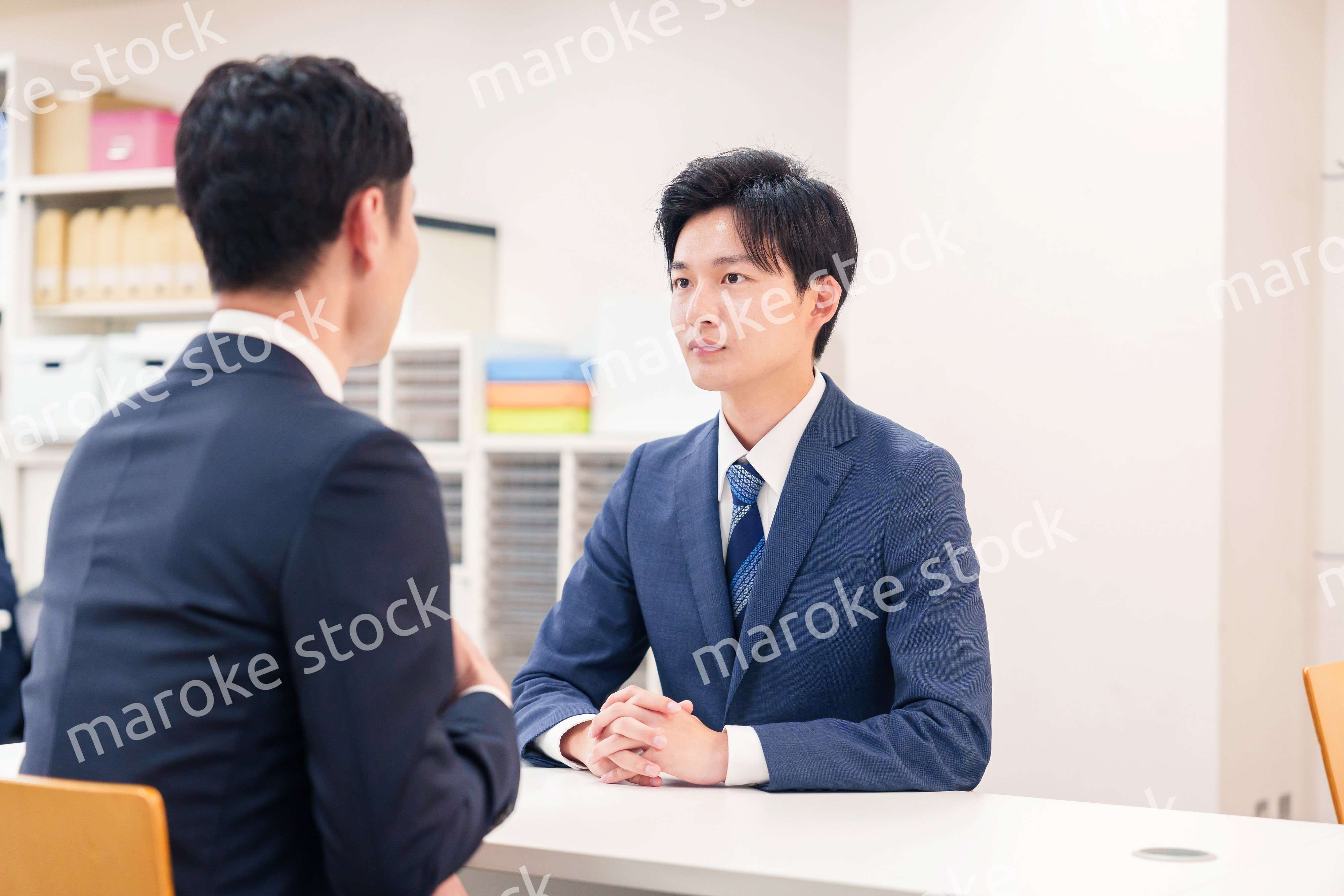 窓口で来客の対応をするビジネスマン