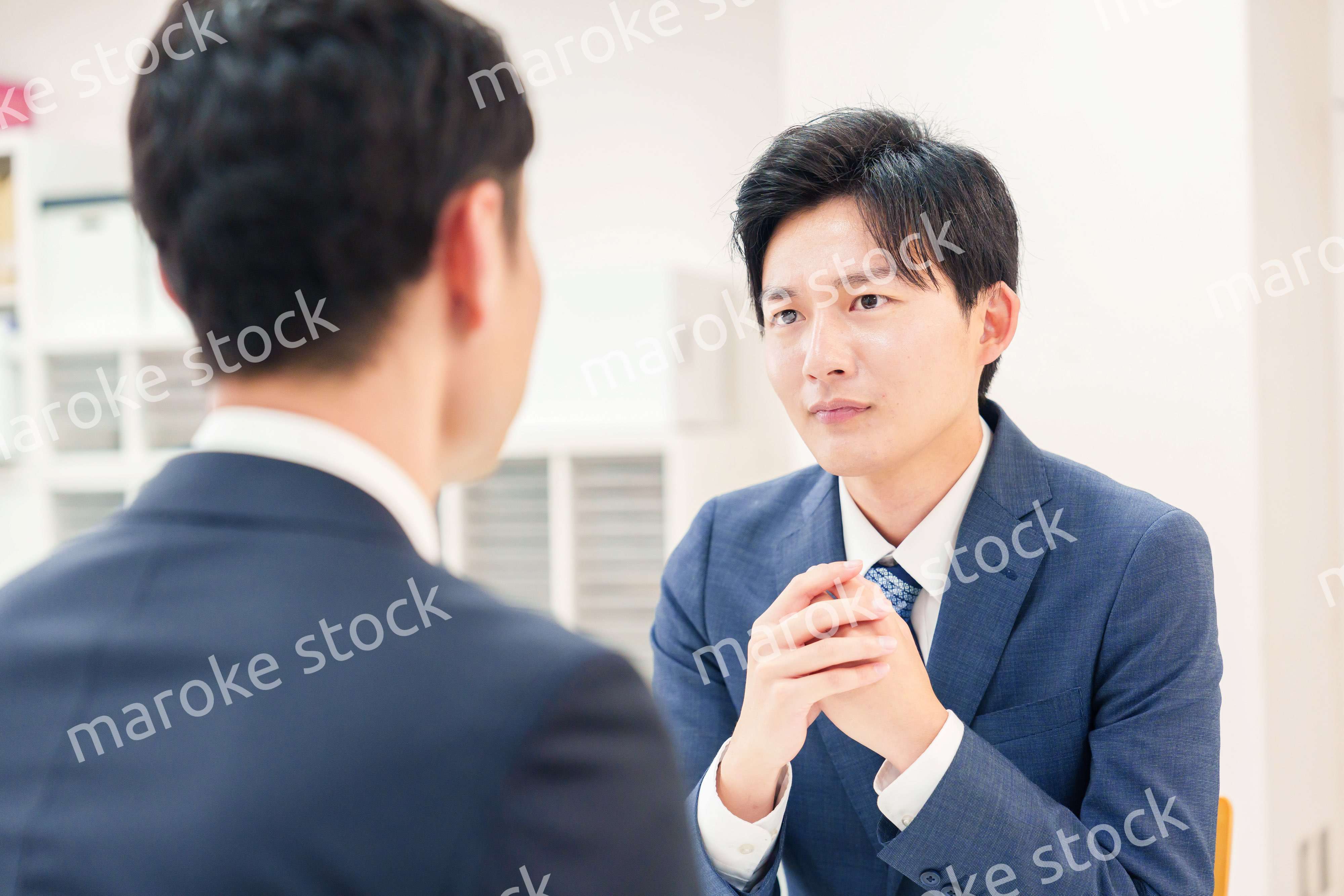 窓口で来客の対応をするビジネスマン