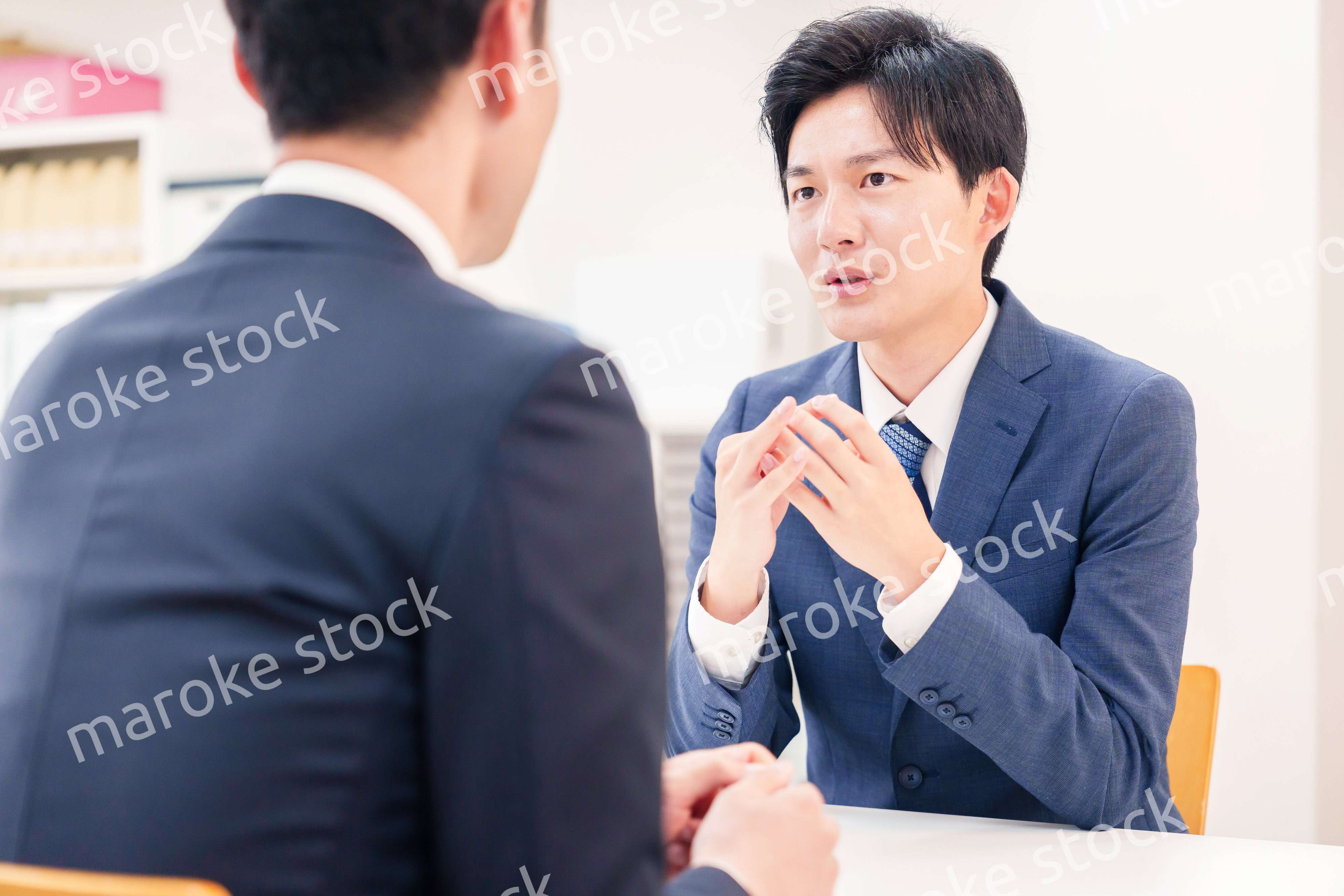 窓口で来客の対応をするビジネスマン