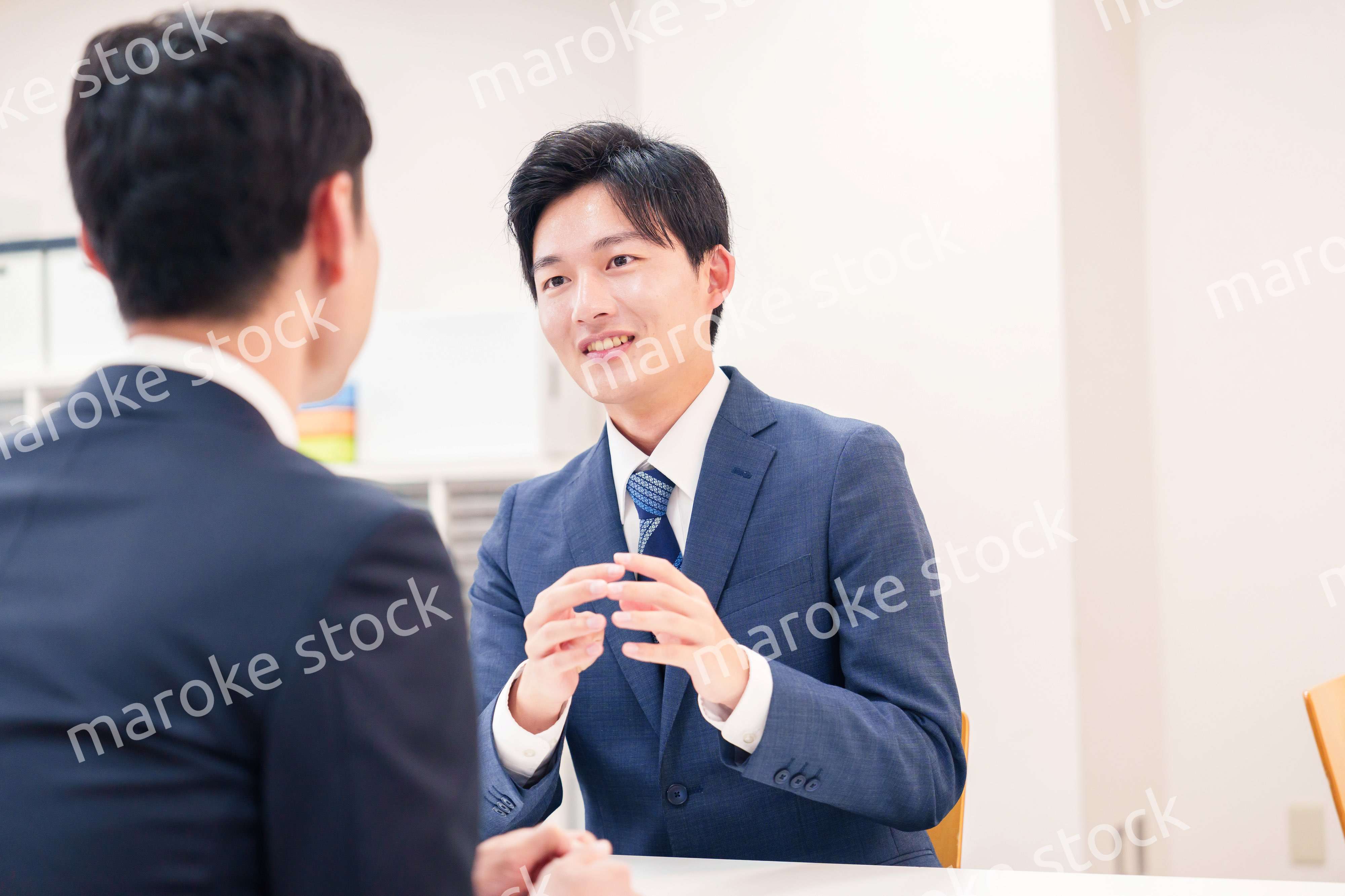 窓口で来客の対応をするビジネスマン