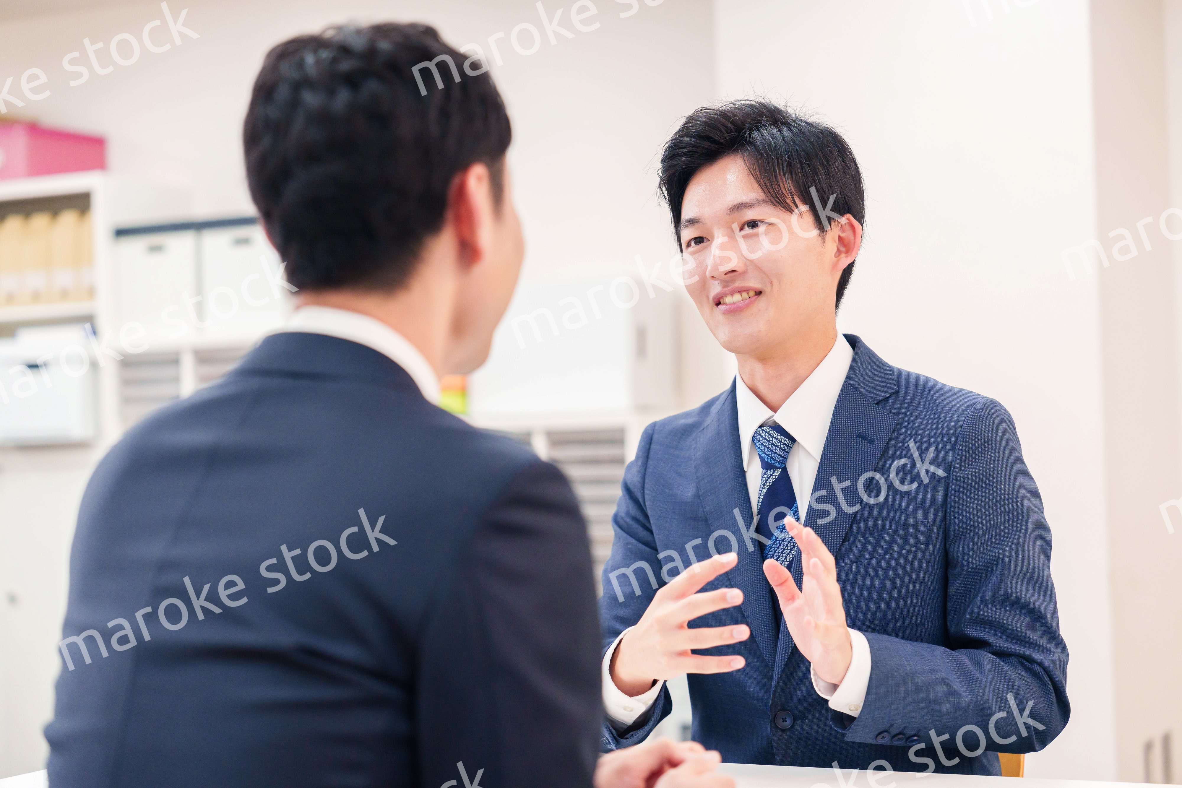 窓口で来客の対応をするビジネスマン