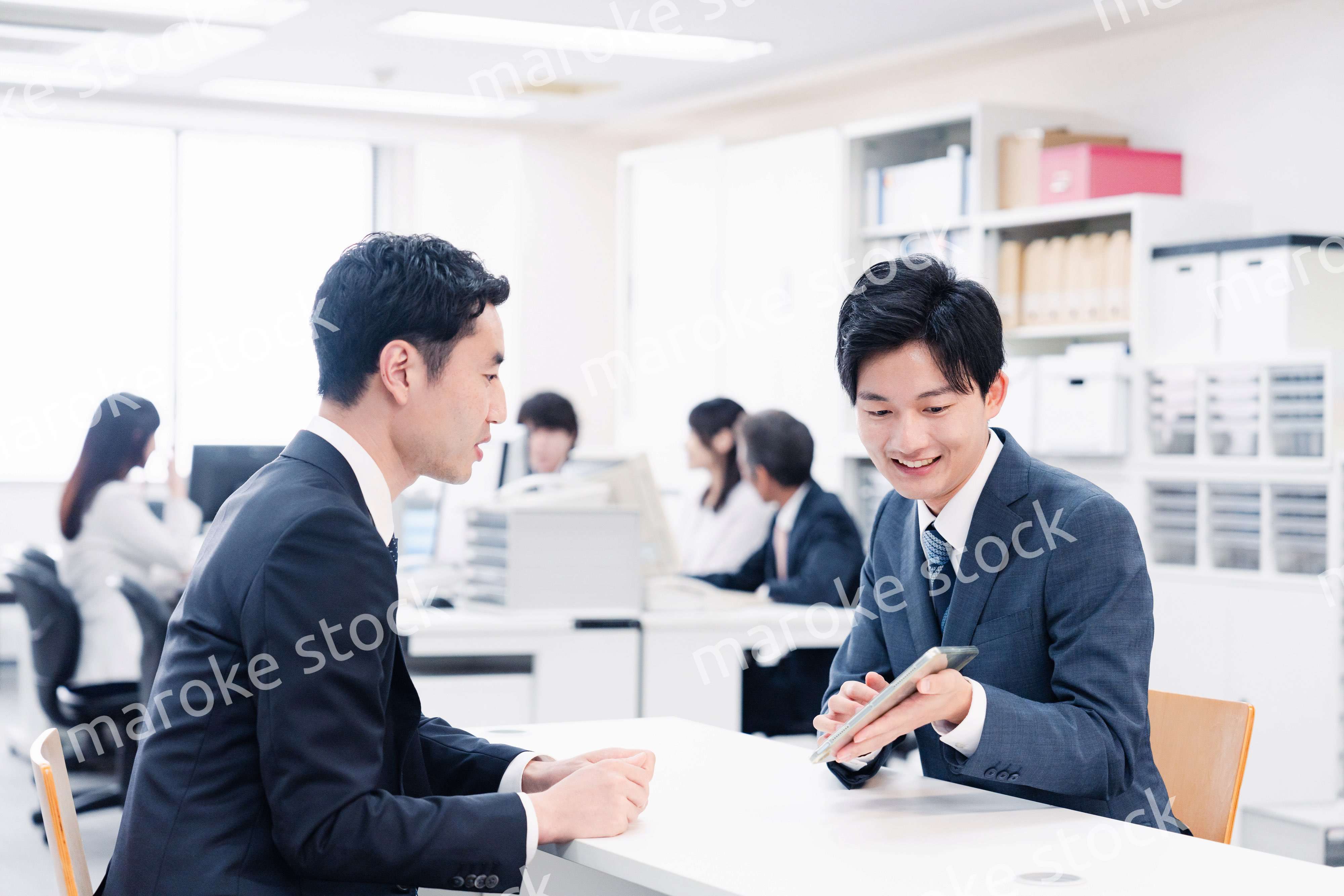 窓口でタブレットを用いて案内をする男性スタッフ