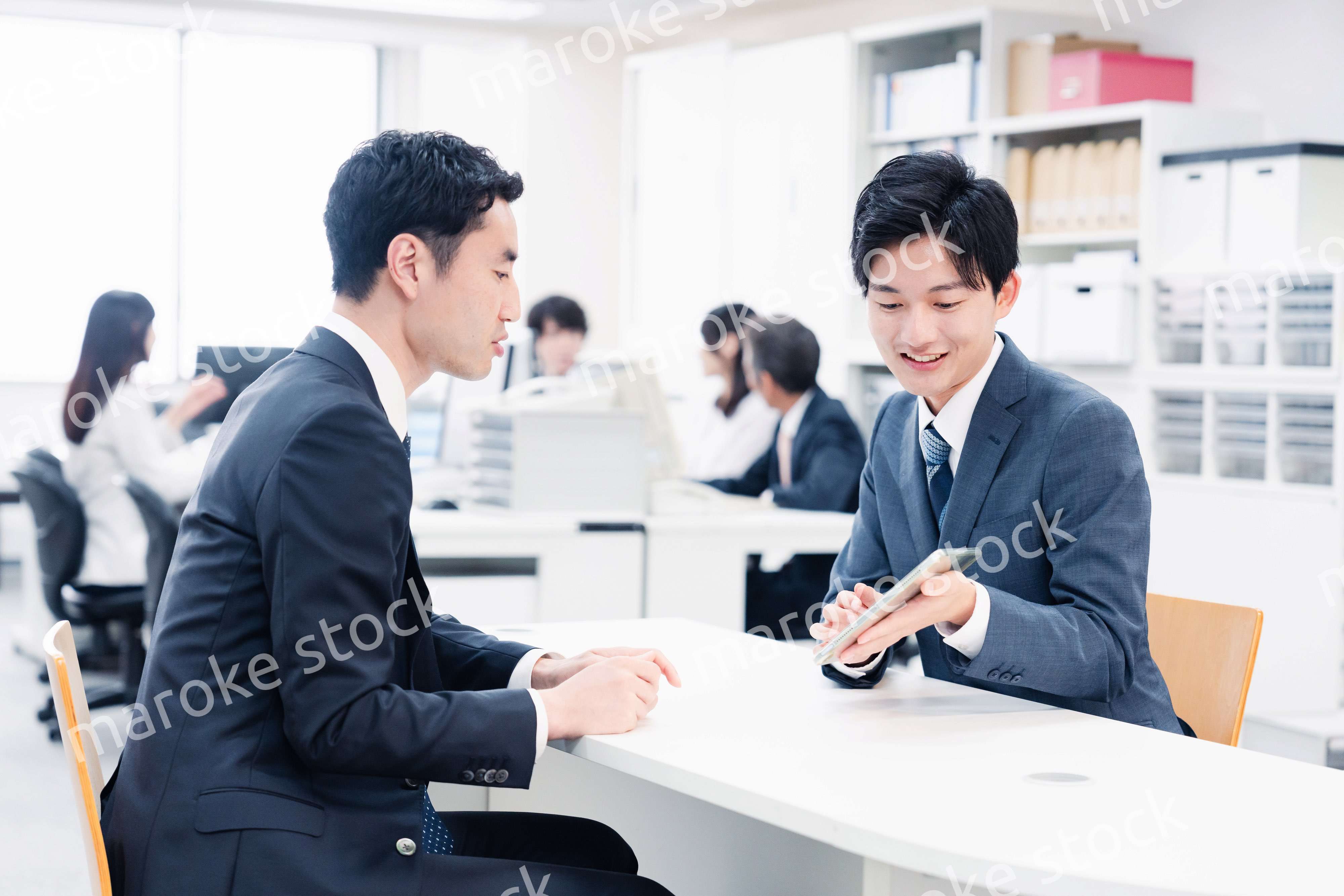 窓口でタブレットを用いて案内をする男性スタッフ