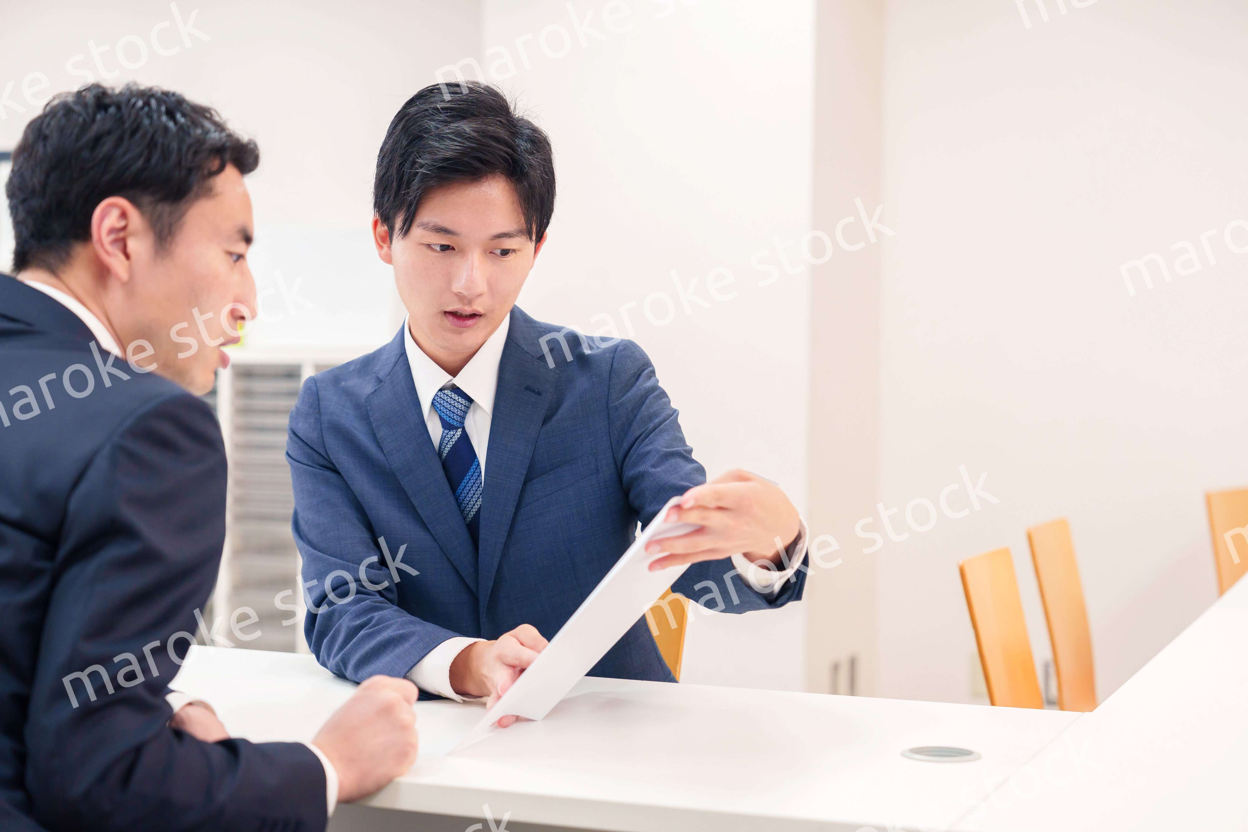 窓口で来客の対応をするビジネスマン