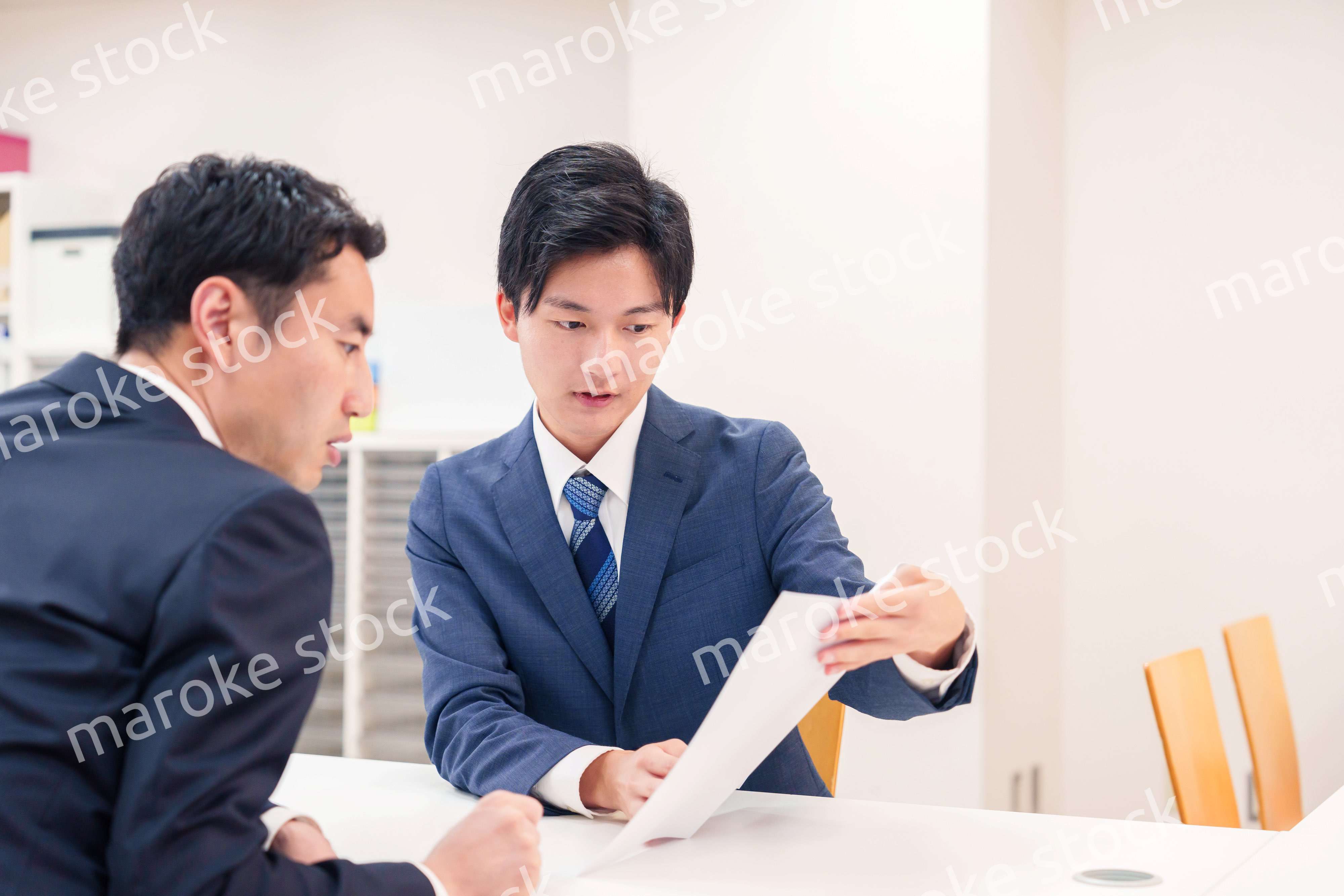 窓口で来客の対応をするビジネスマン