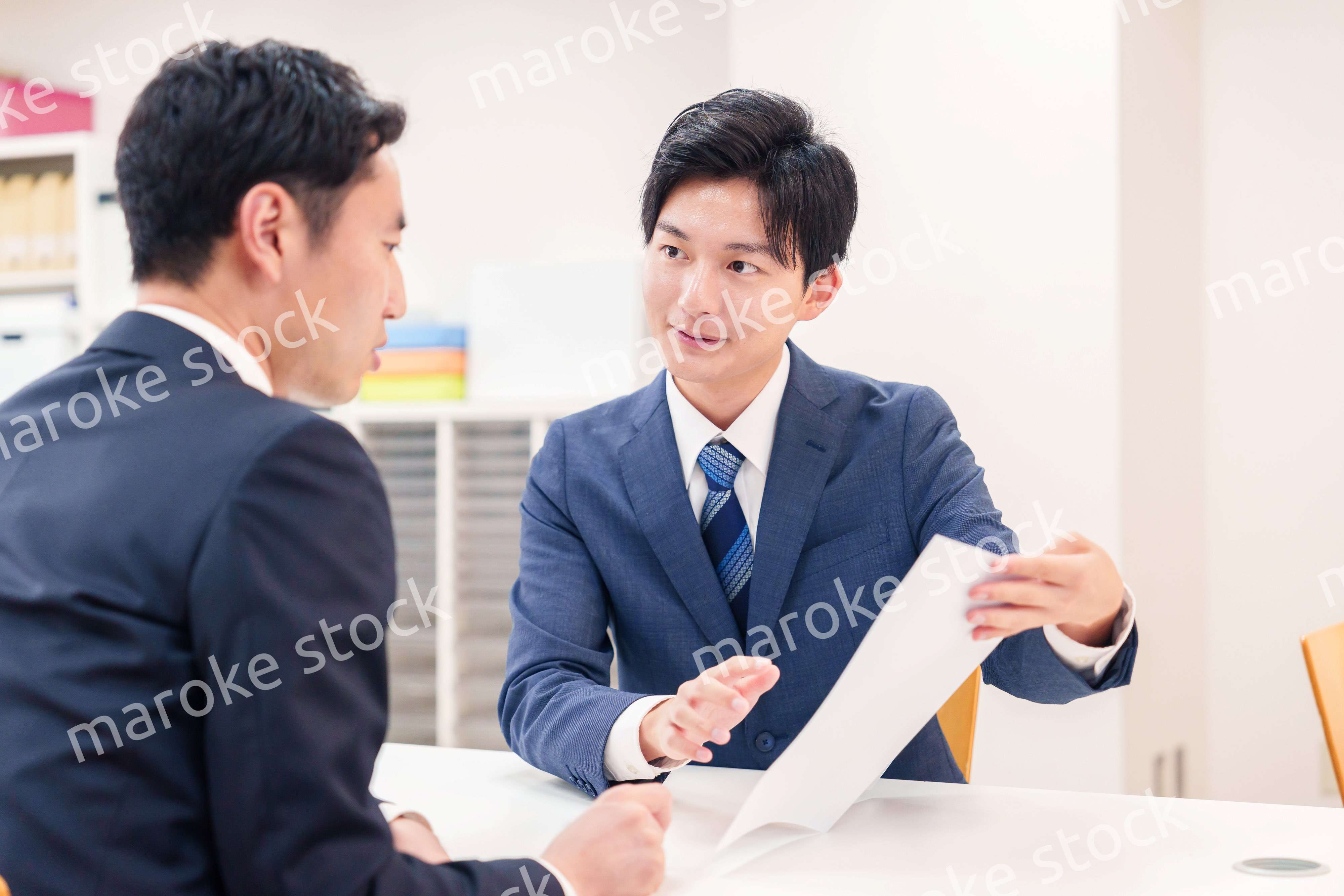 窓口で来客の対応をするビジネスマン