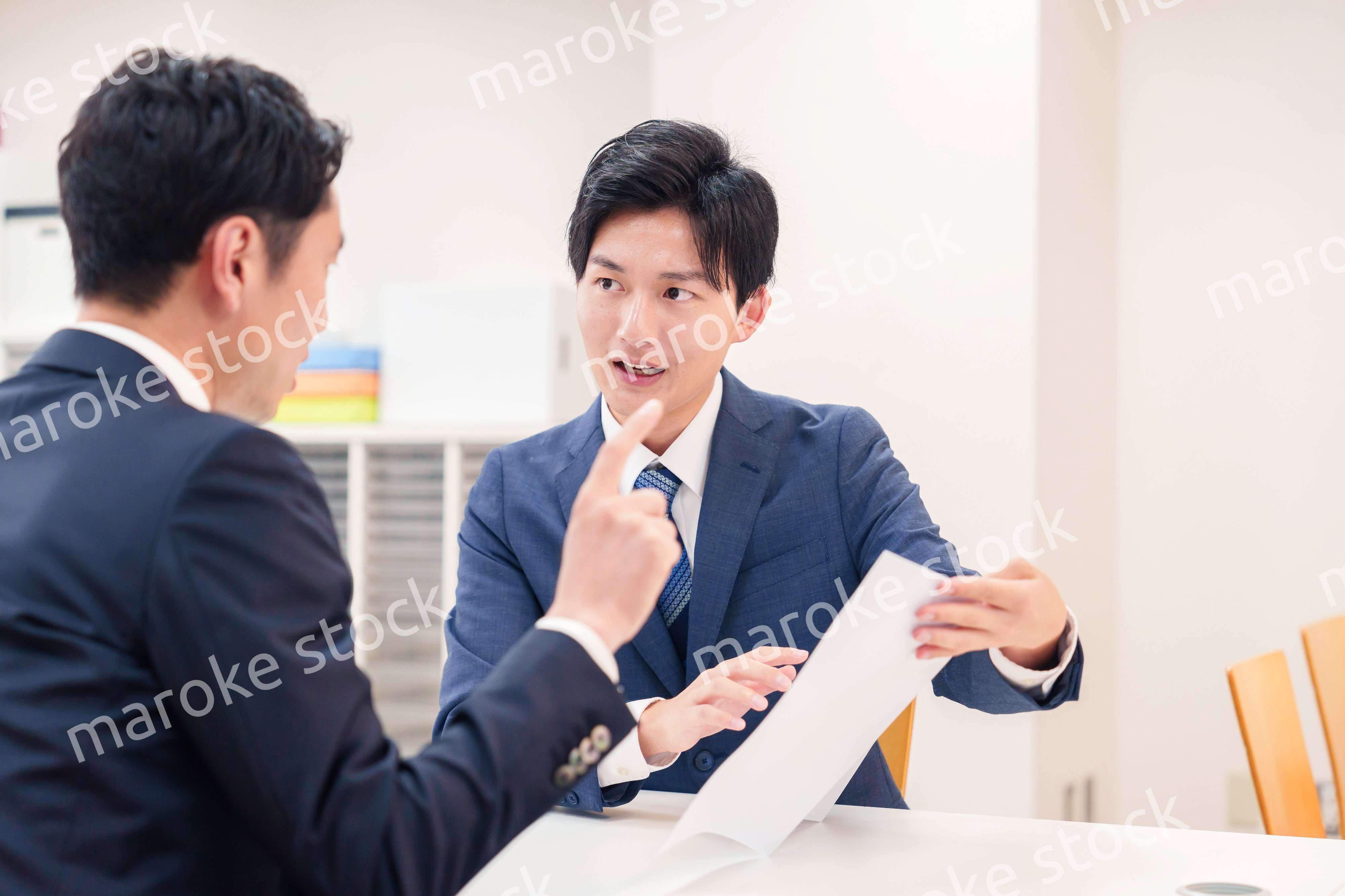 窓口で来客の対応をするビジネスマン