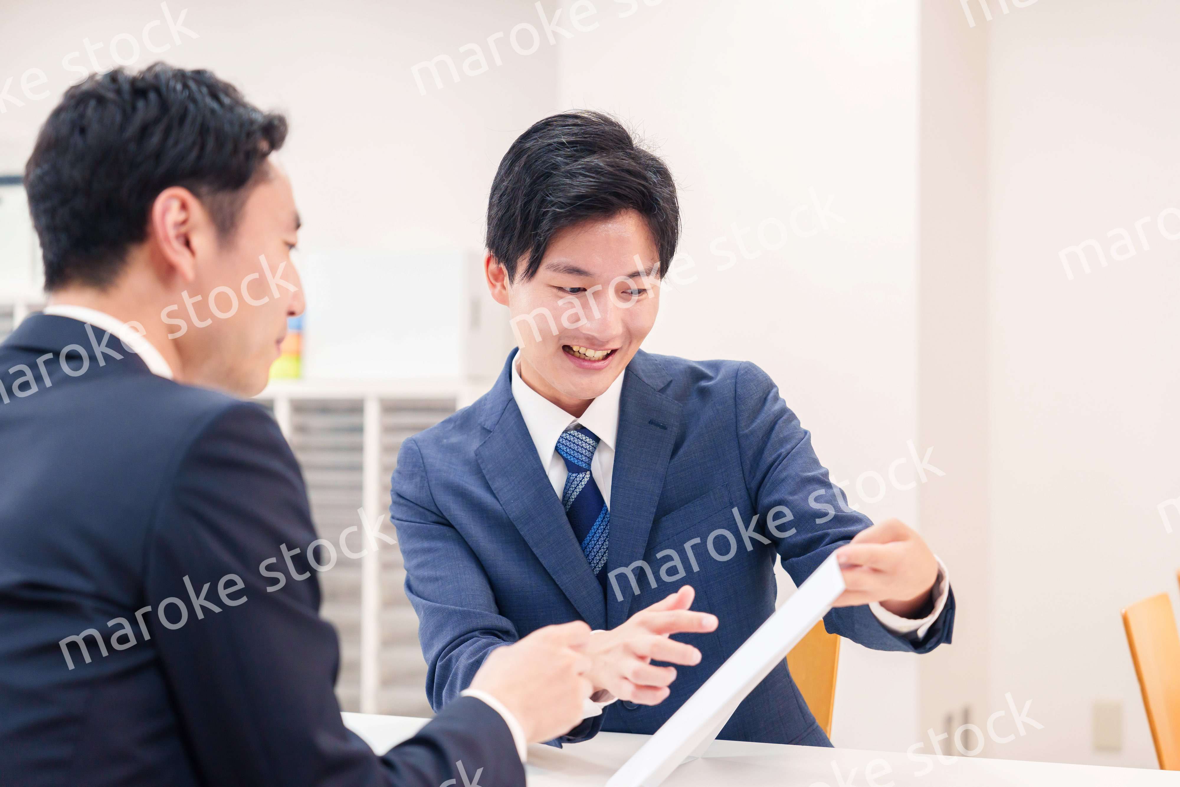 窓口で来客の対応をするビジネスマン