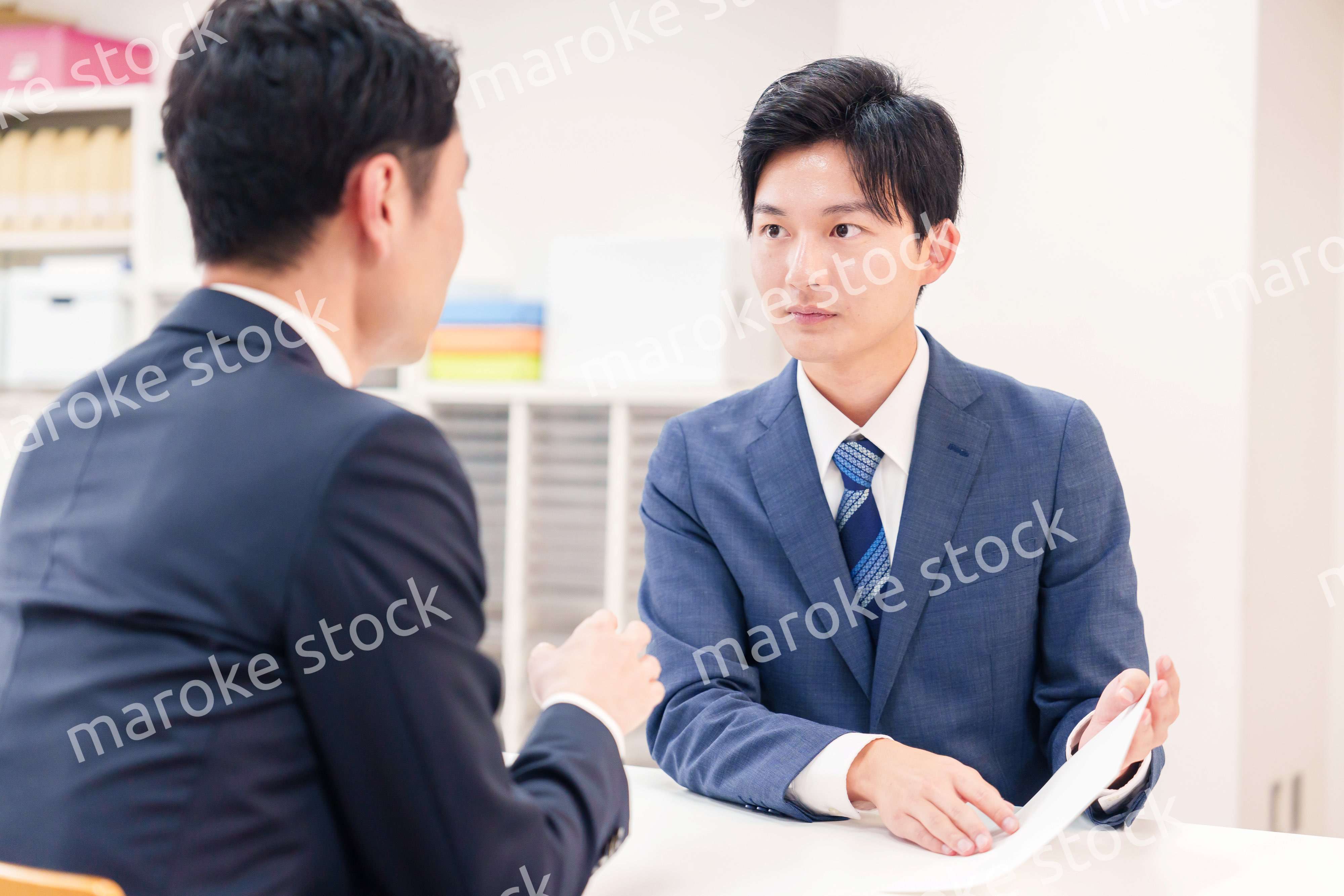 窓口で来客の対応をするビジネスマン