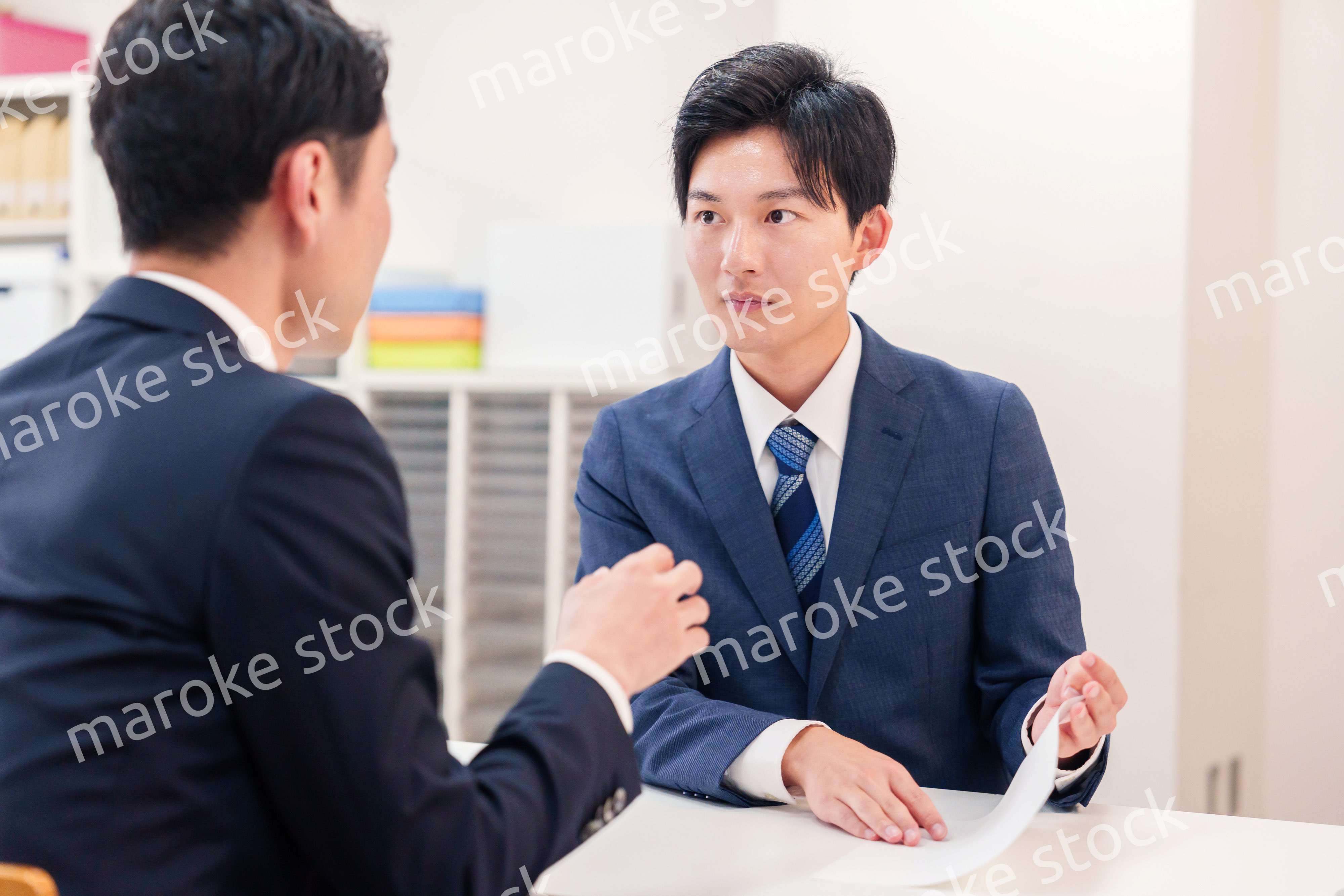 窓口で来客の対応をするビジネスマン