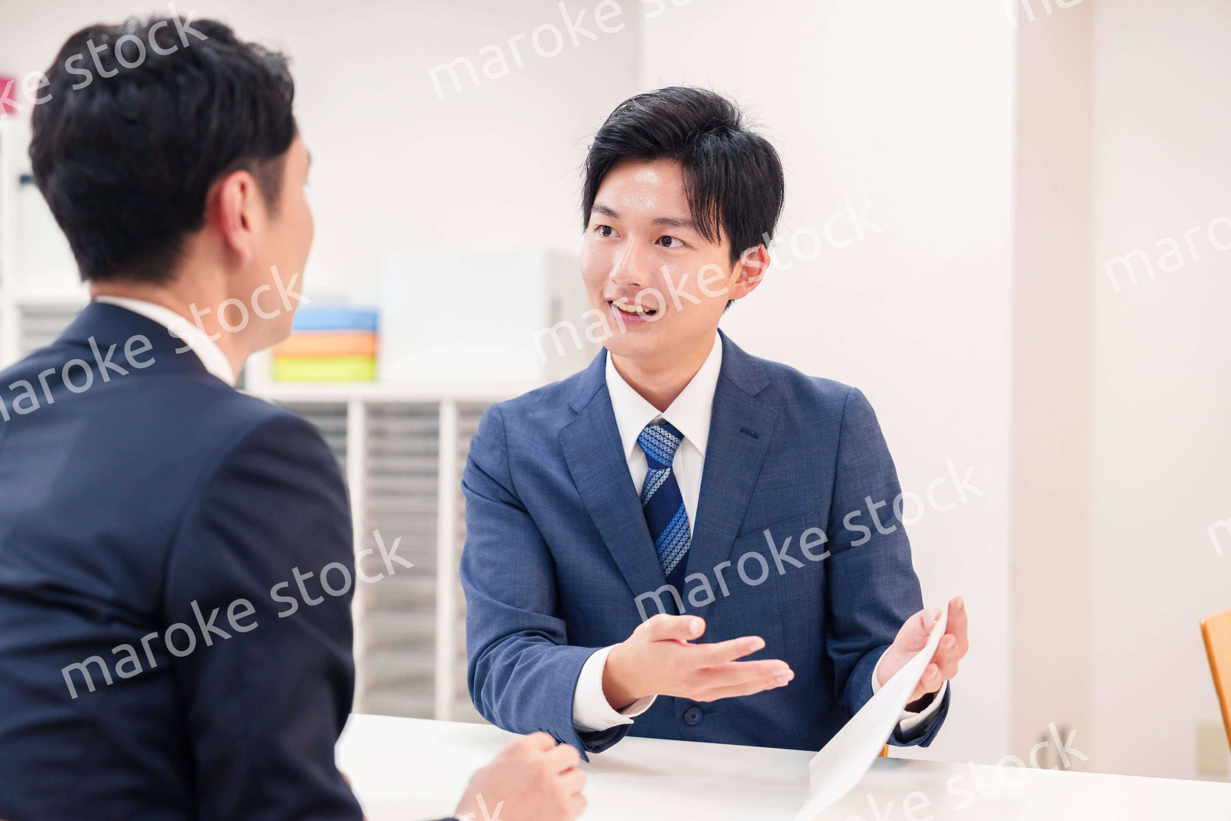 窓口で来客の対応をするビジネスマン