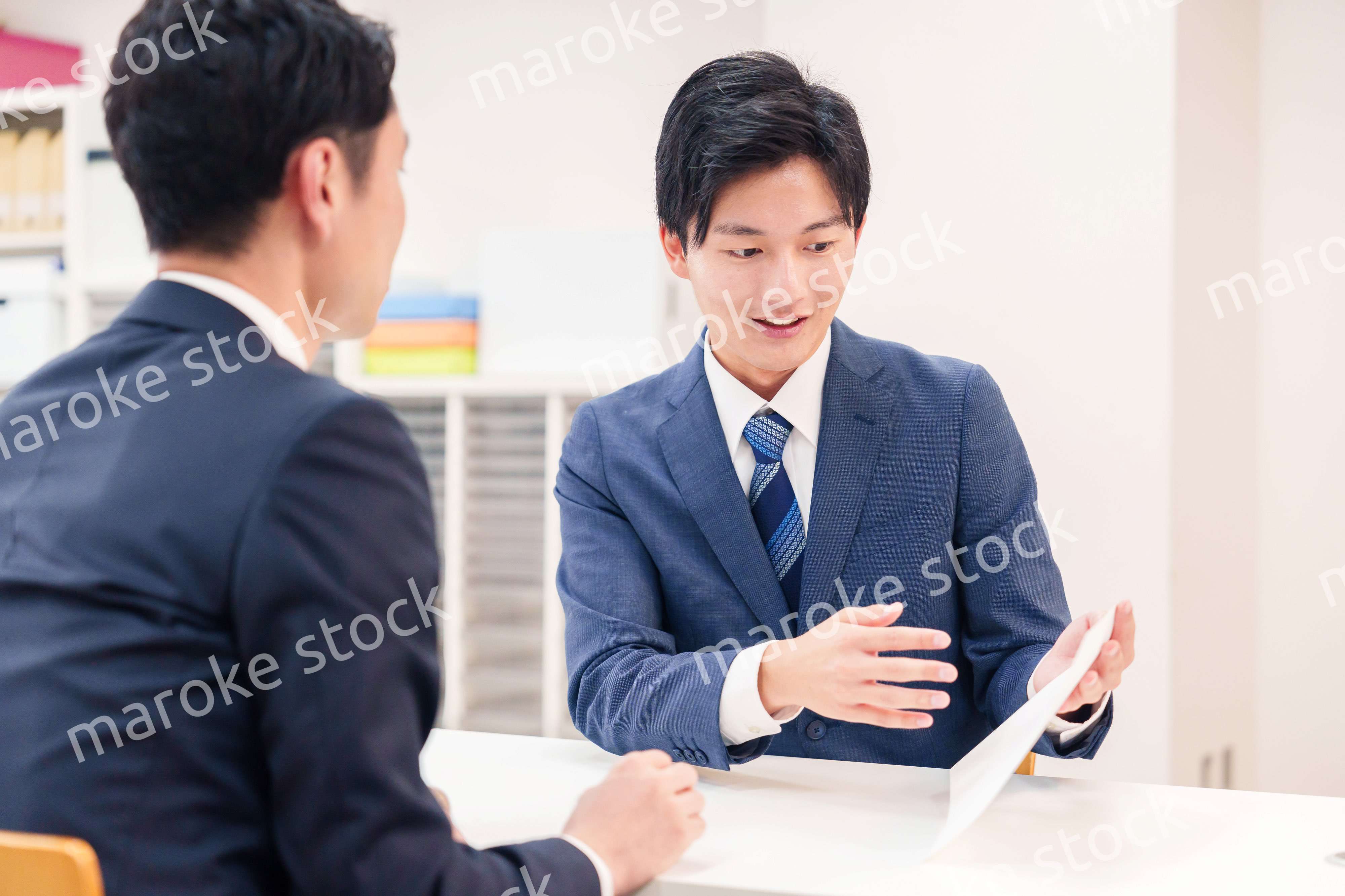 窓口で来客の対応をするビジネスマン