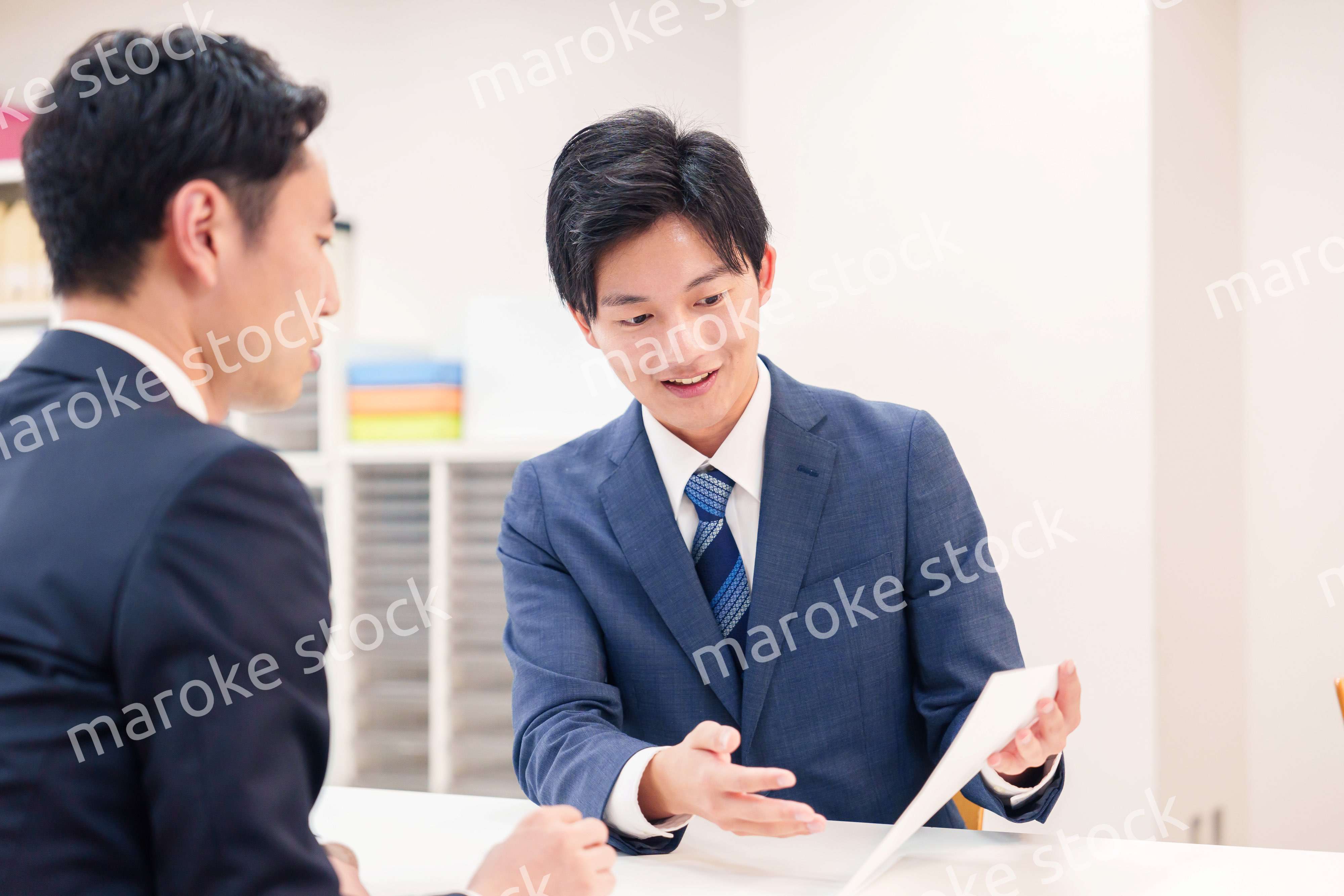 窓口で来客の対応をするビジネスマン