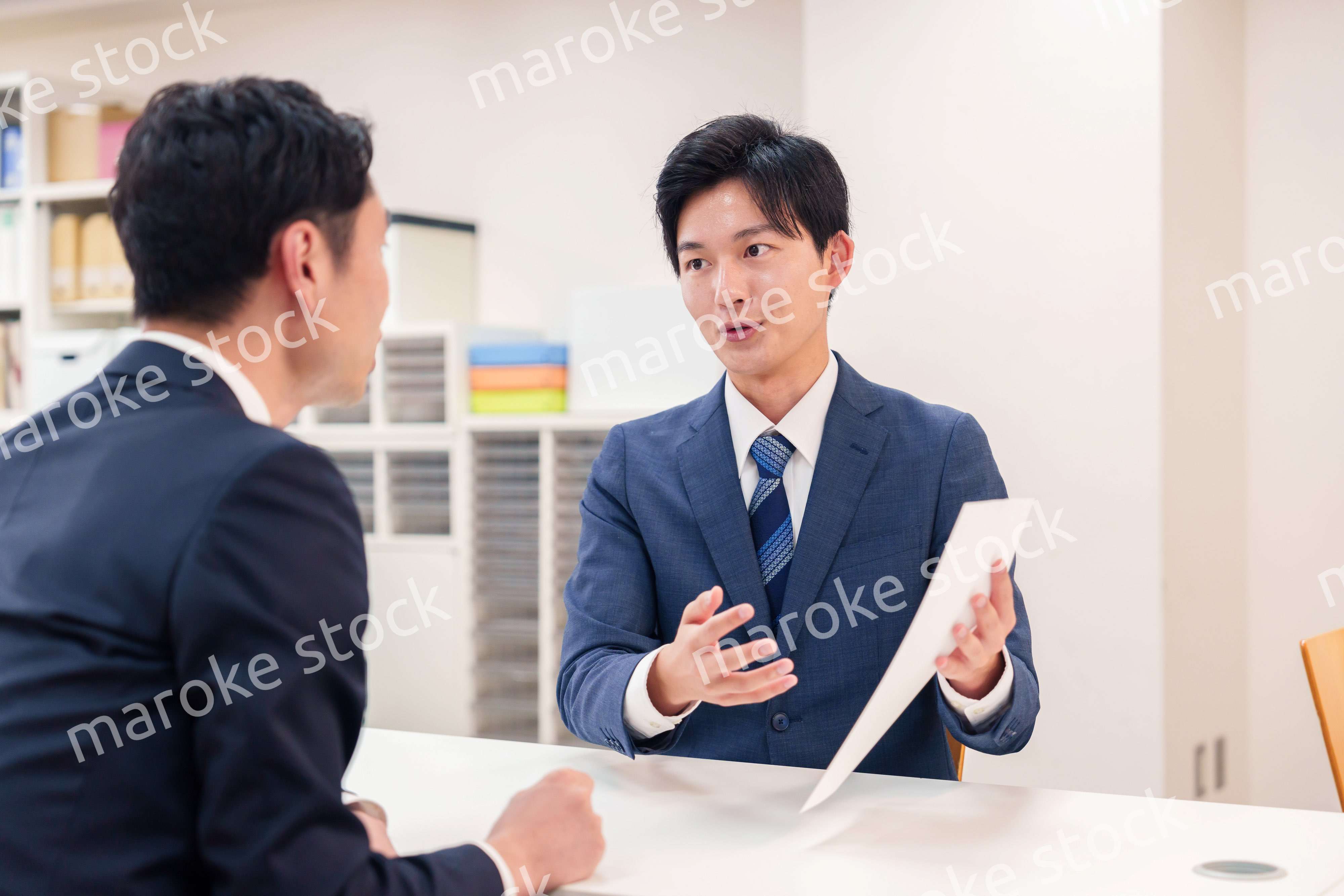 窓口で来客の対応をするビジネスマン