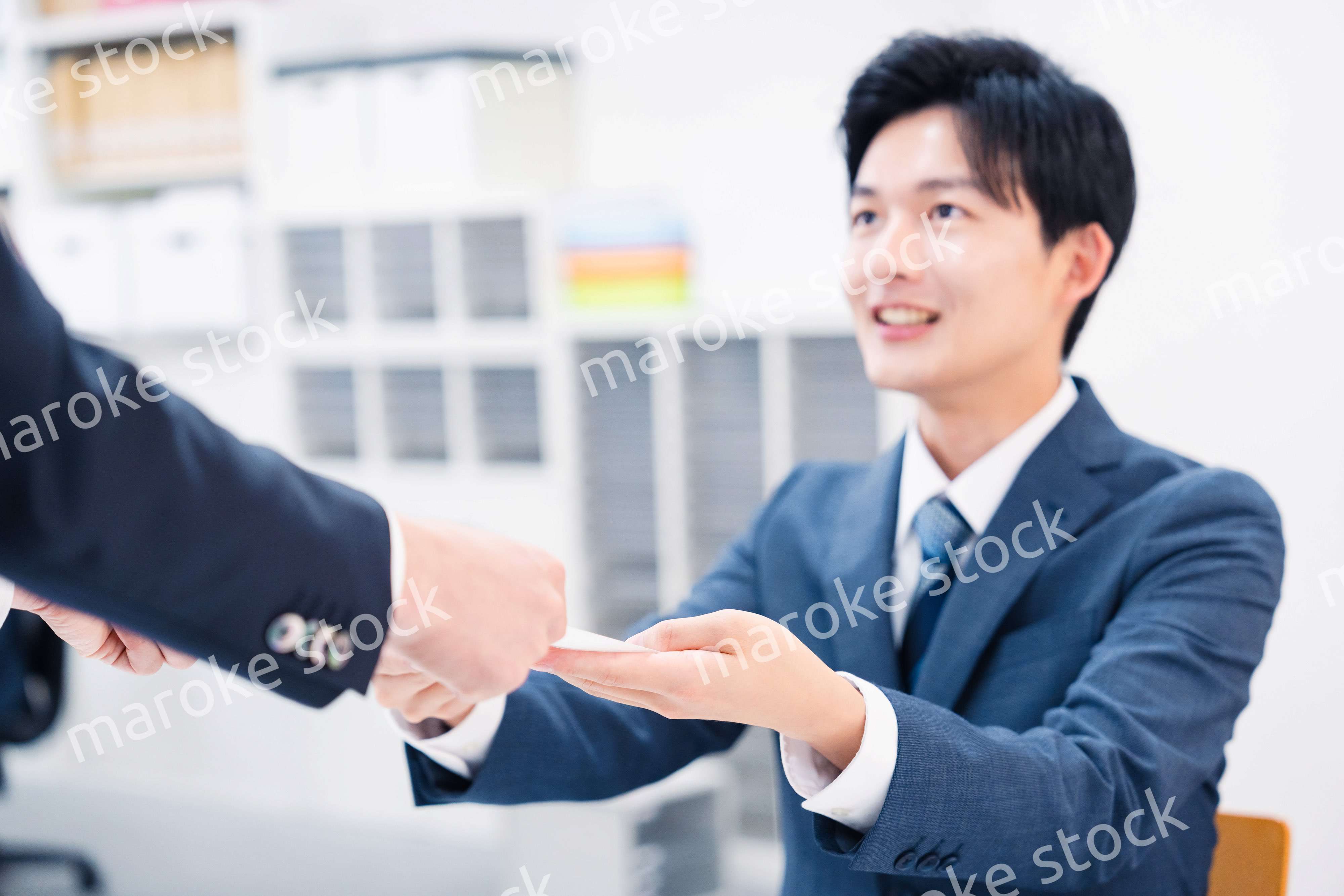 窓口で紙の書面の取り交わしをするビジネスマン