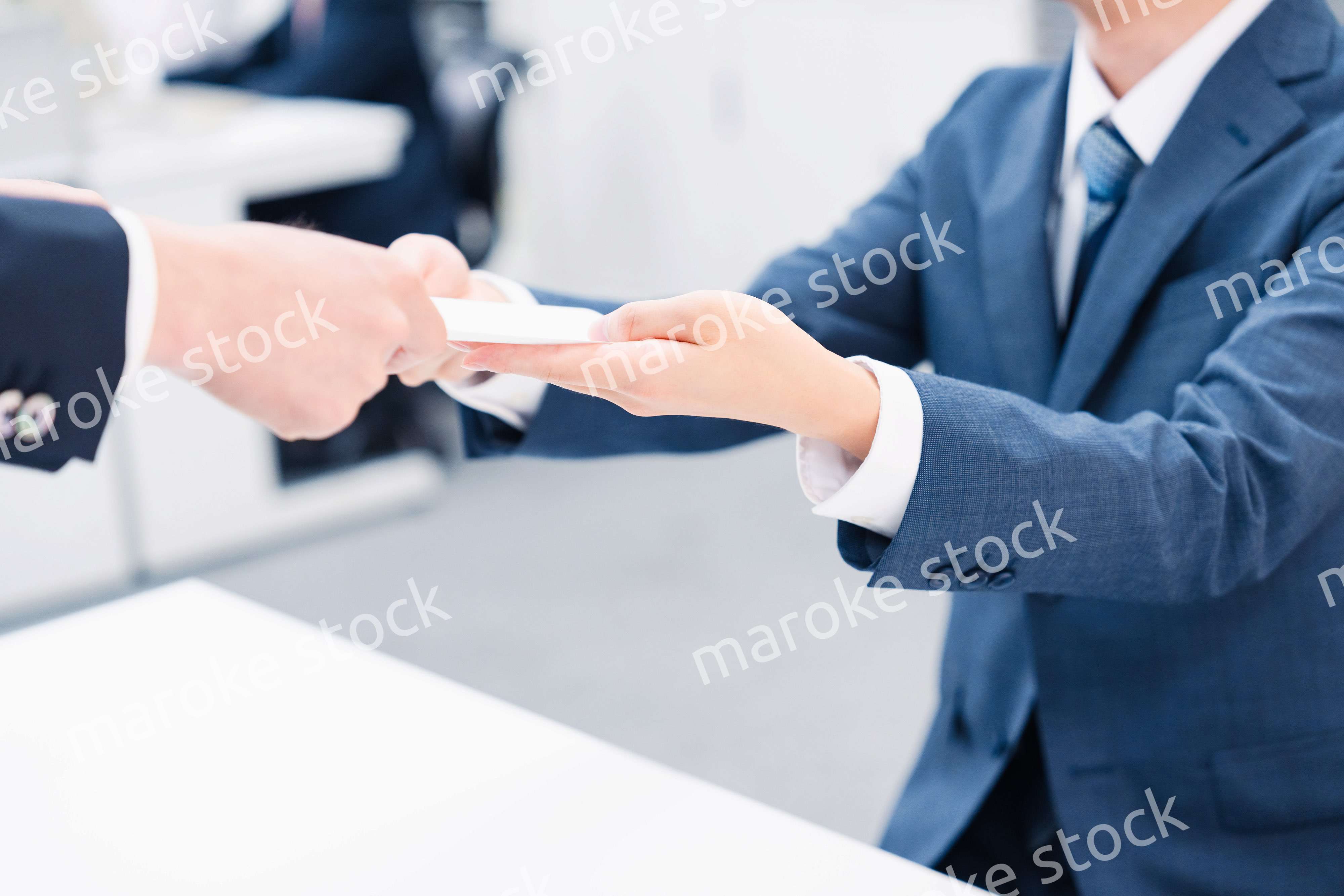 窓口で紙の書面の取り交わしをするビジネスマン