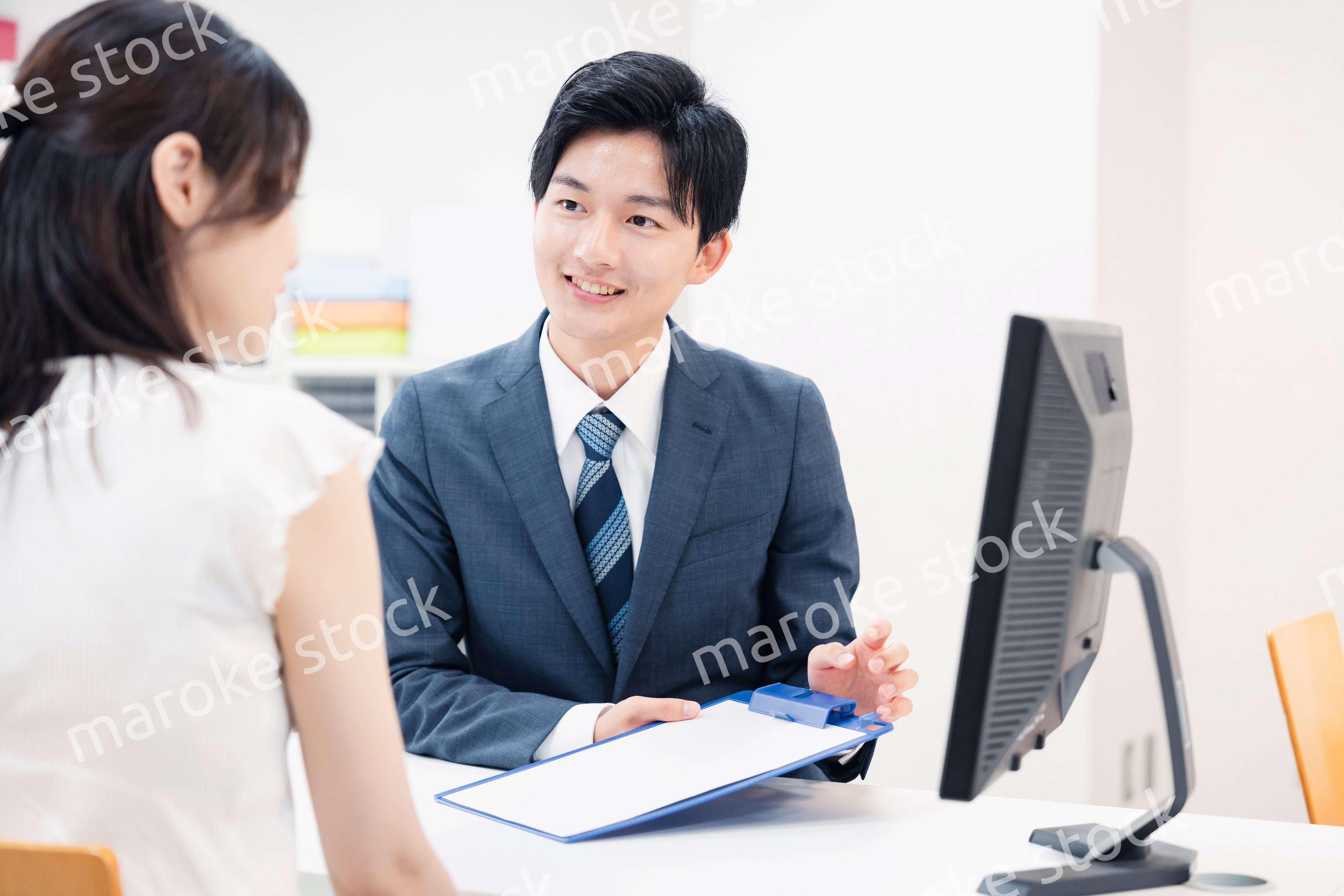窓口で顧客の要望を聞く男性スタッフ