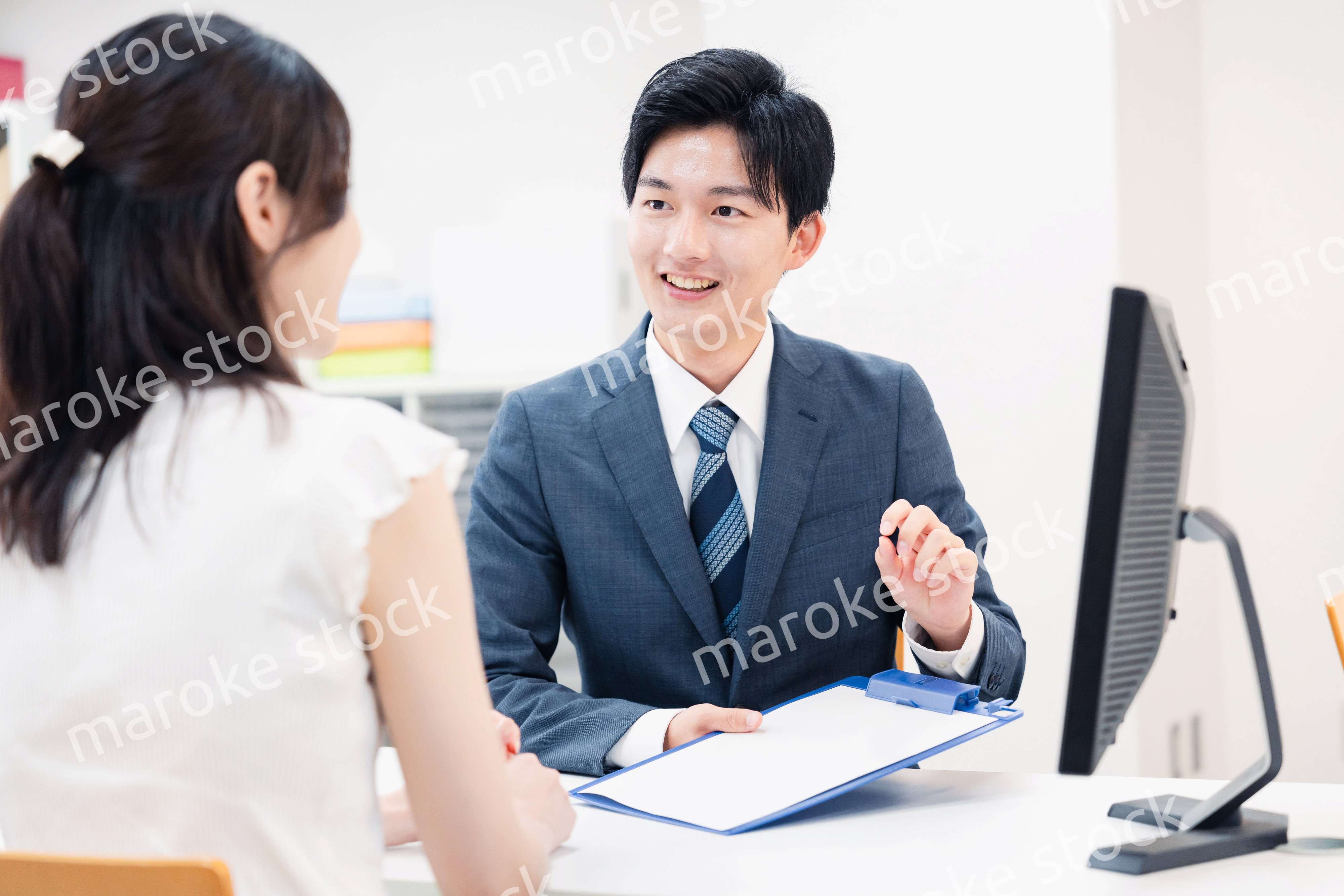 窓口で顧客の要望を聞く男性スタッフ