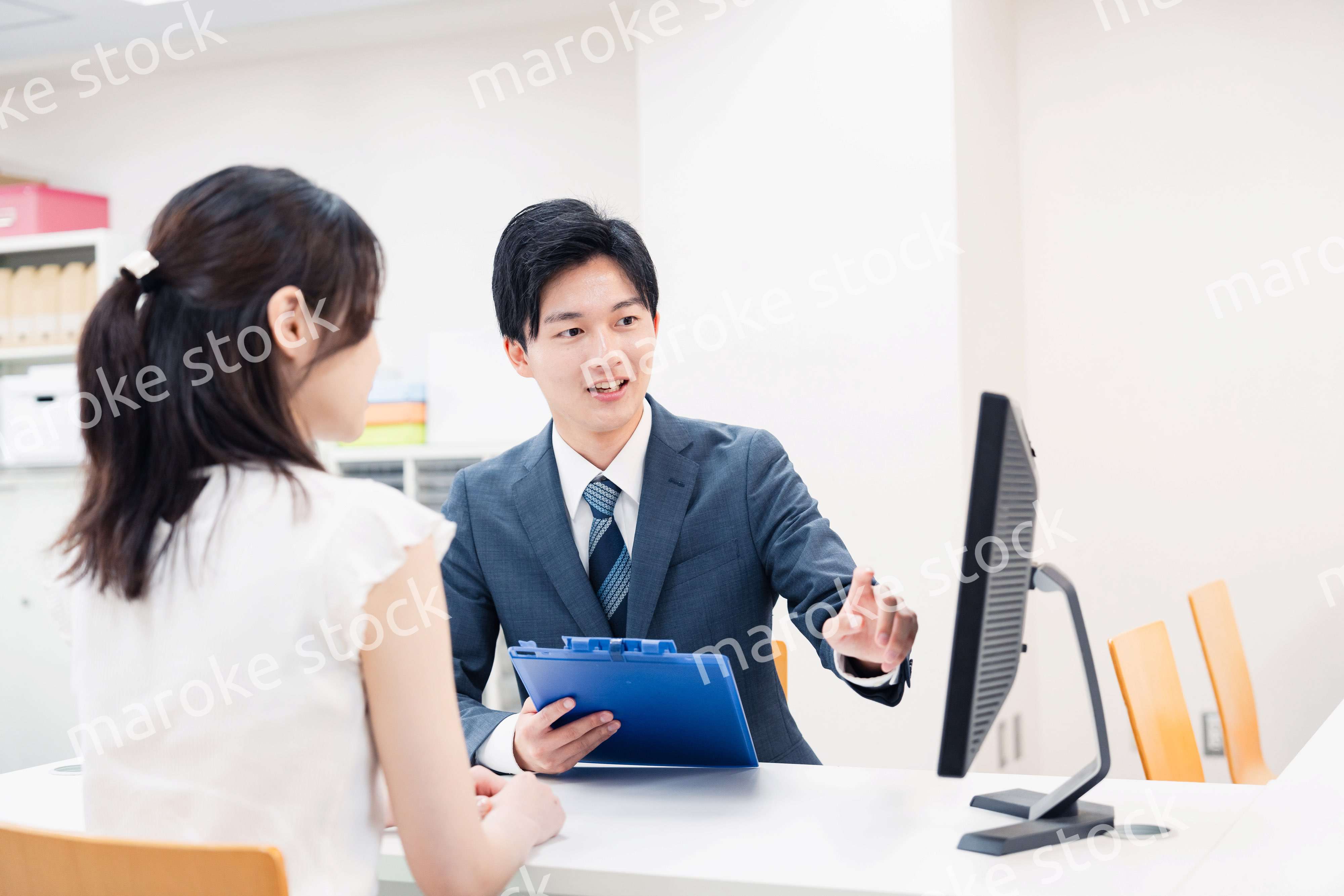 窓口で顧客の要望を聞く男性スタッフ