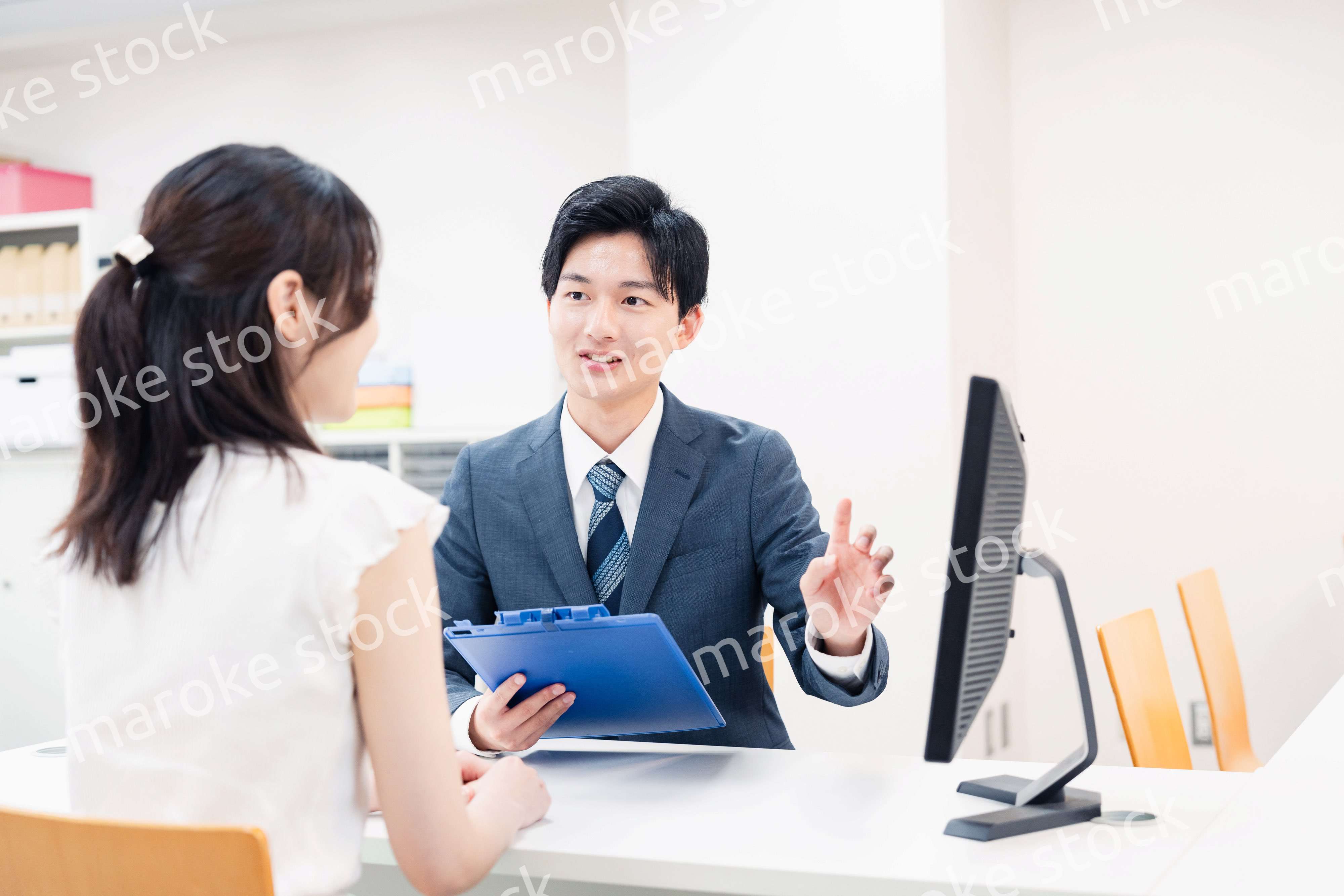 窓口で顧客の要望を聞く男性スタッフ