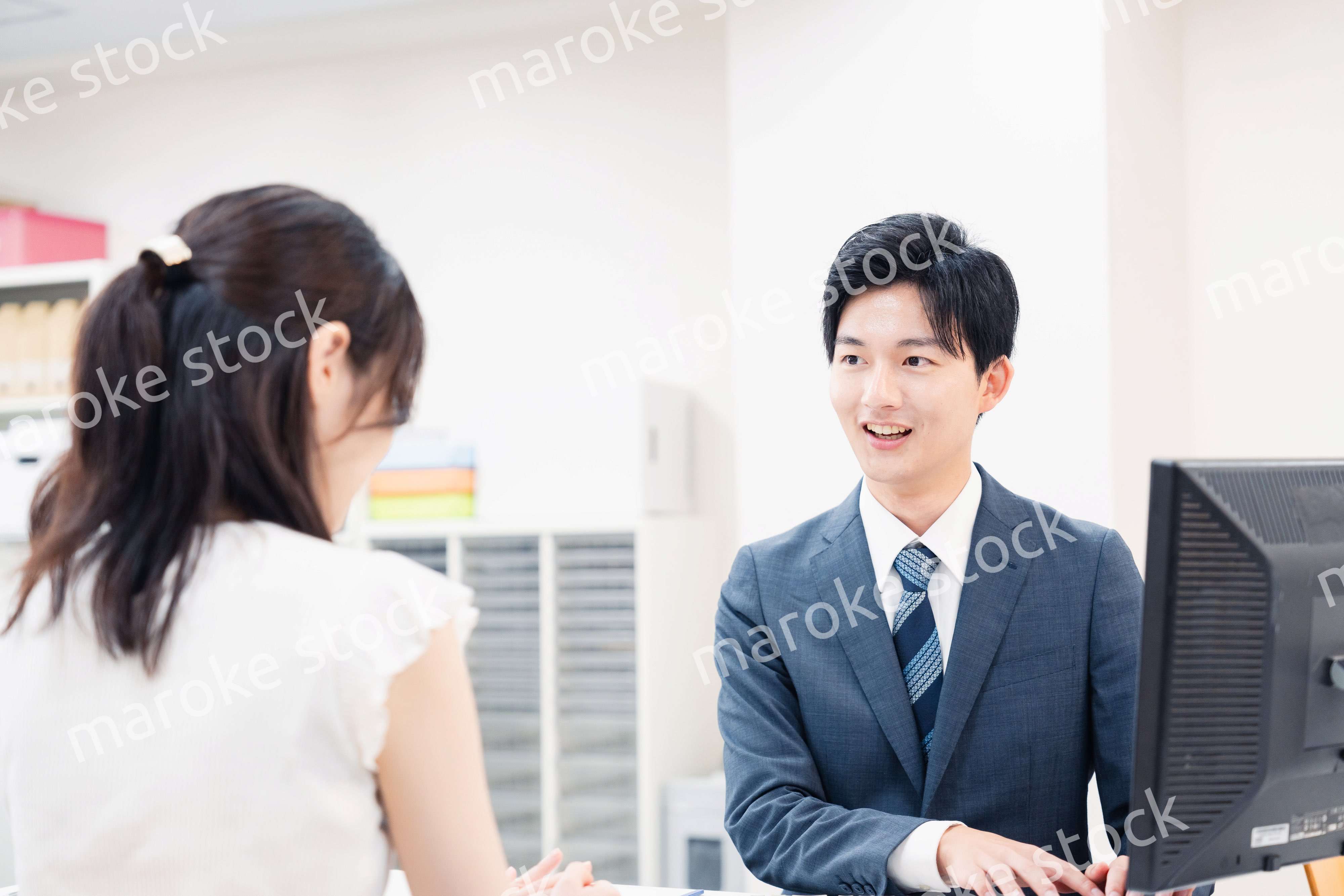 窓口で顧客の要望を聞く男性スタッフ