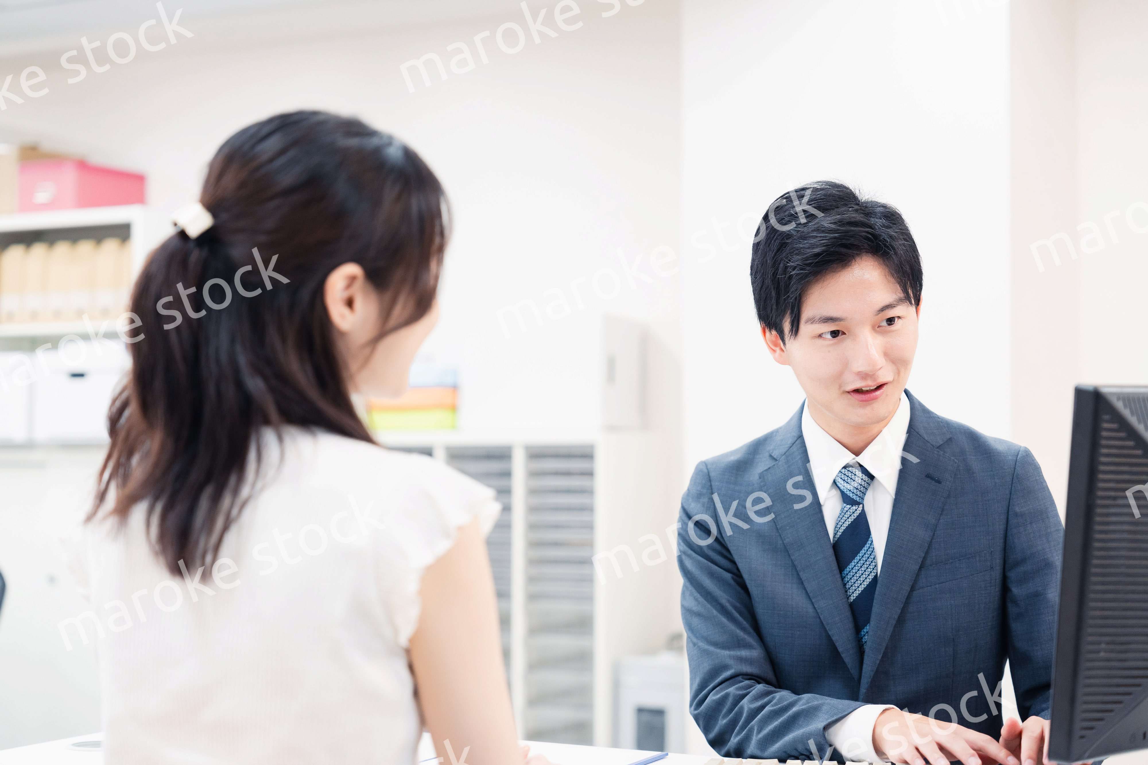 窓口で顧客の要望を聞く男性スタッフ