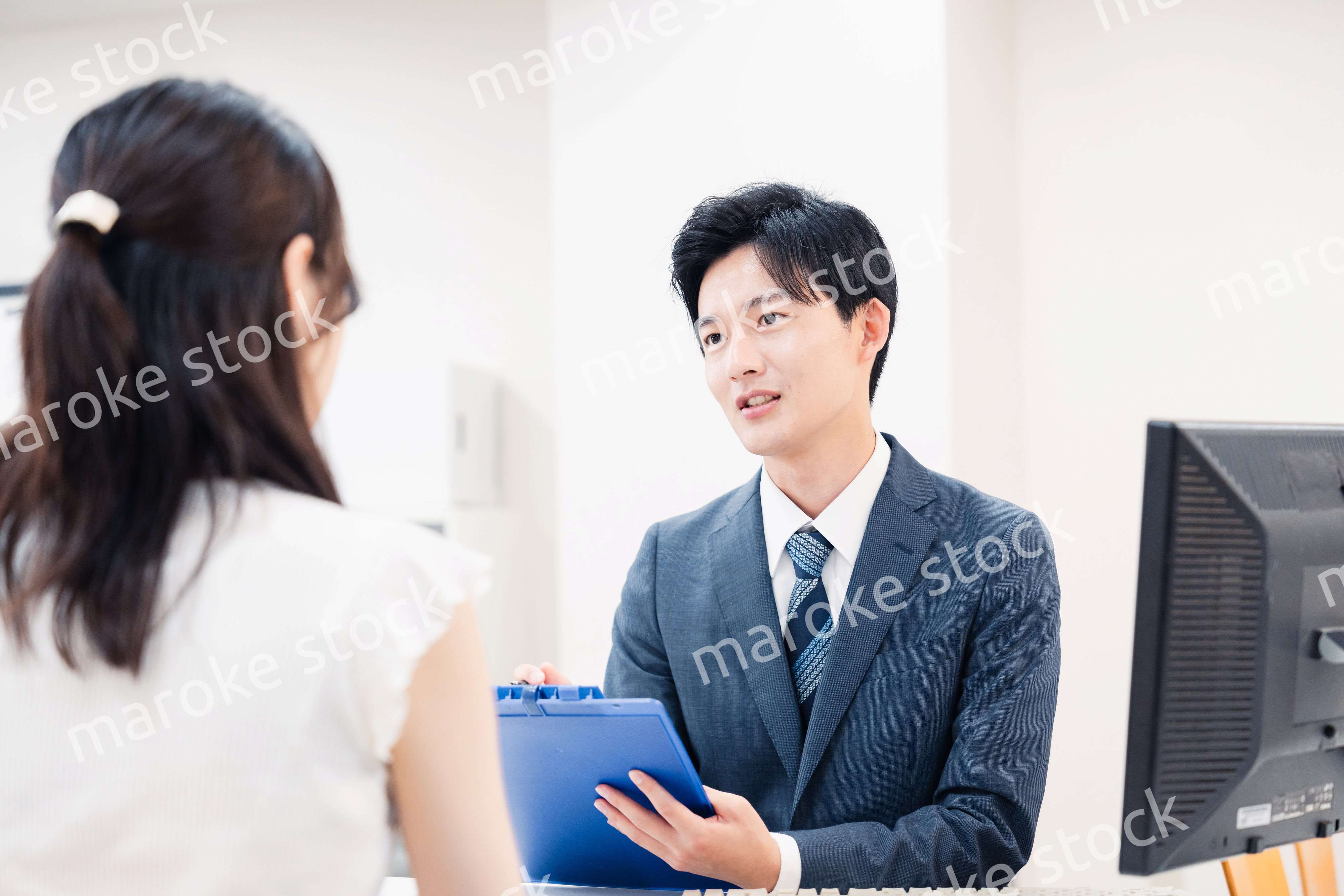 窓口で顧客の要望を聞く男性スタッフ