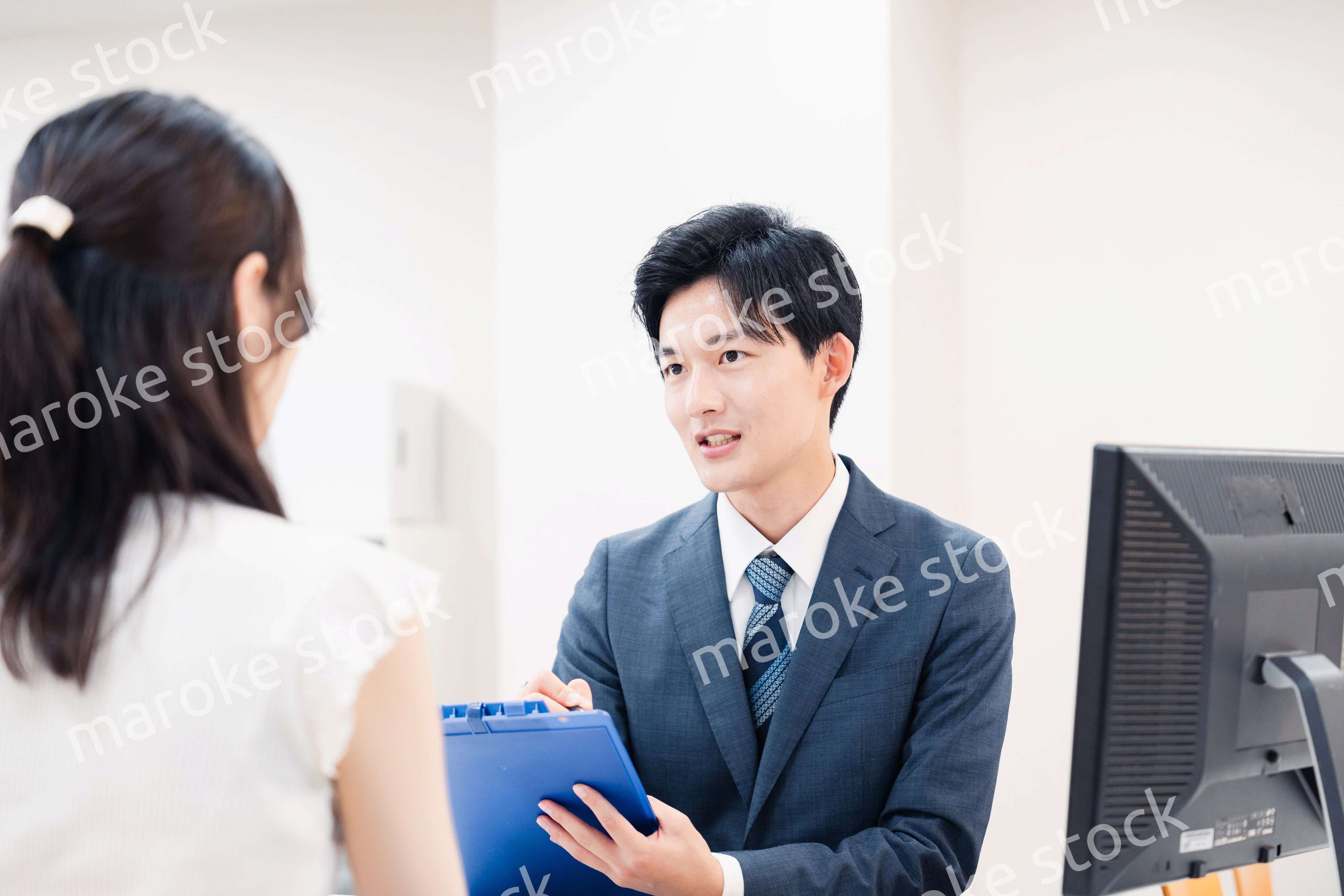 窓口で顧客の要望を聞く男性スタッフ