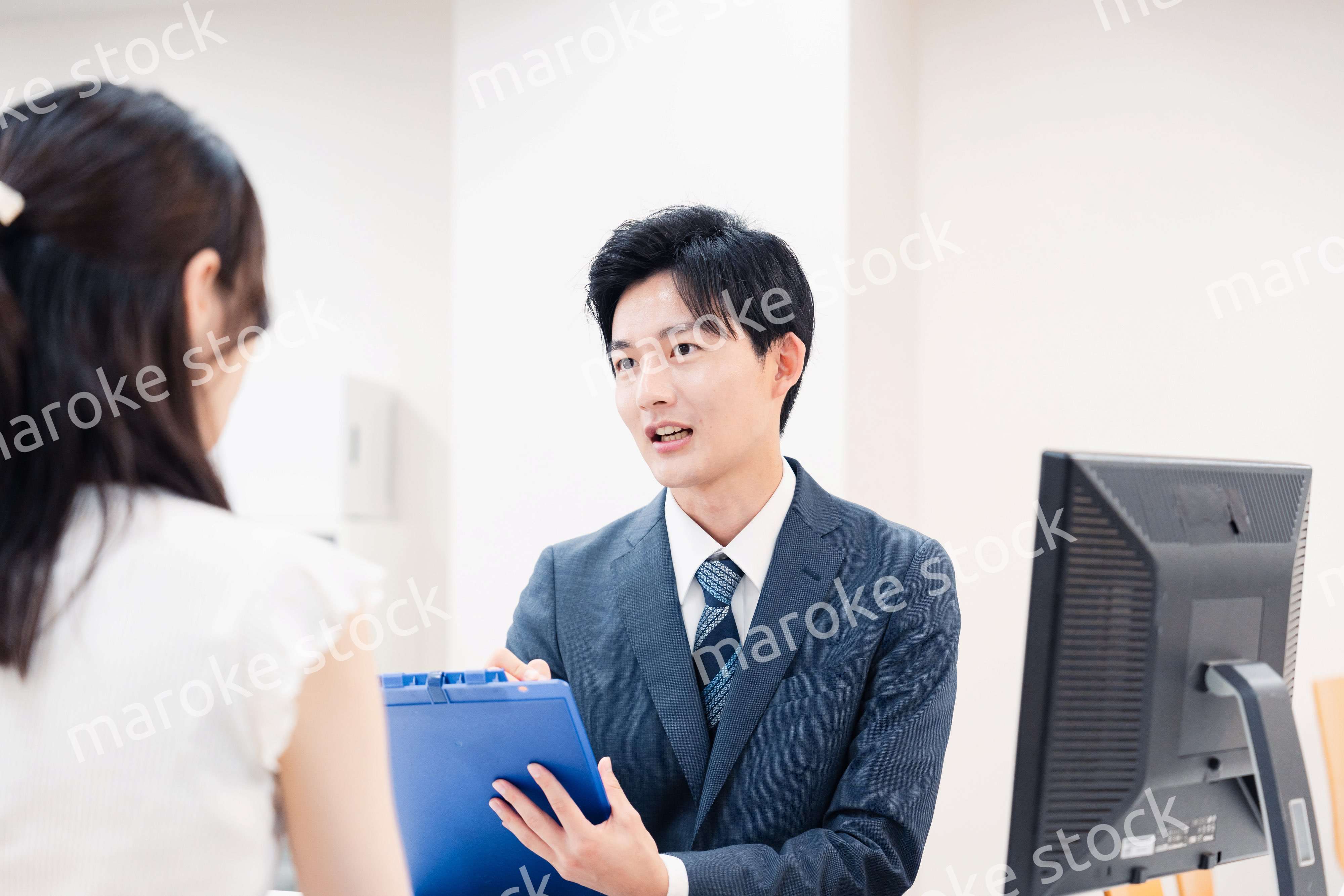 窓口で顧客の要望を聞く男性スタッフ