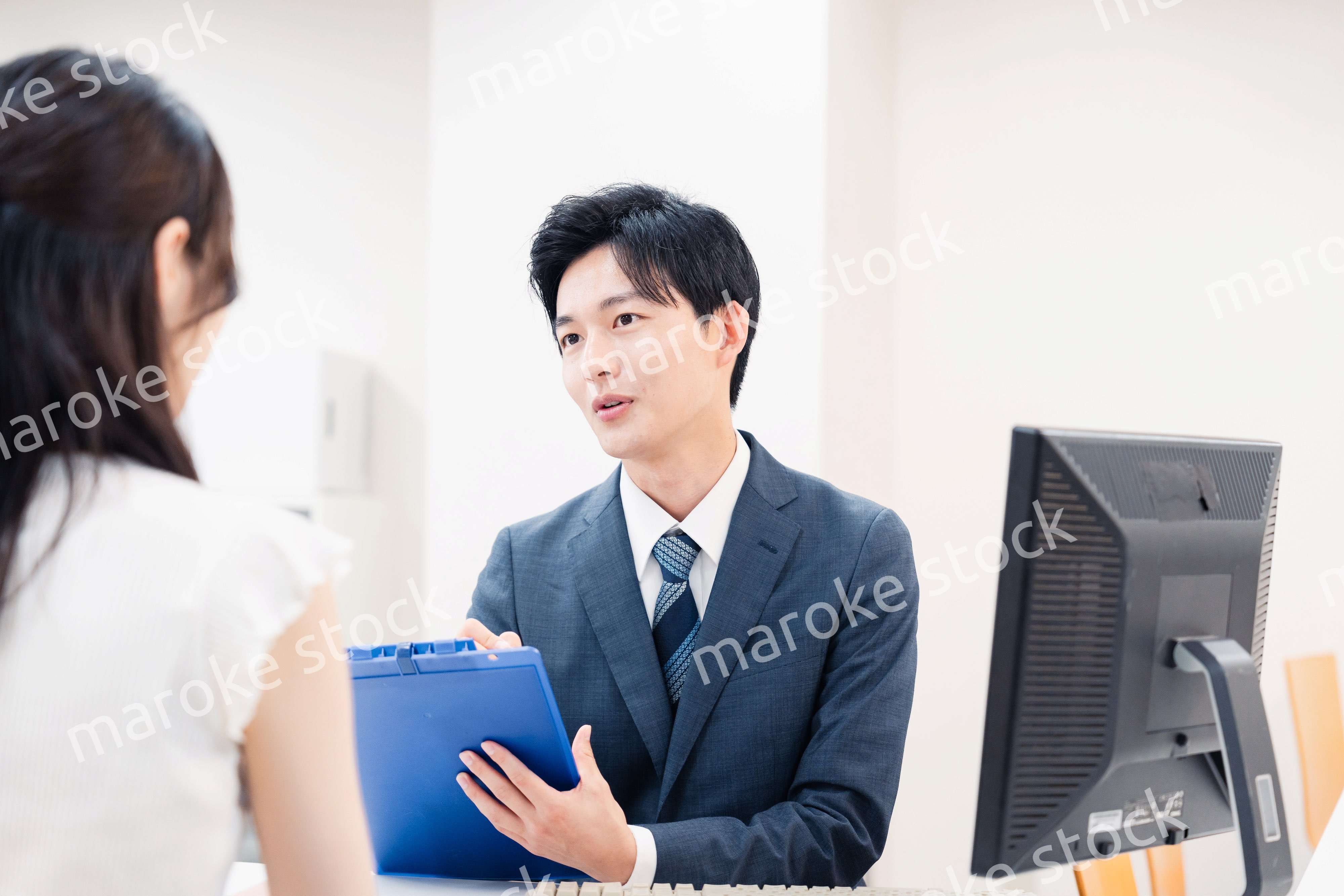 窓口で顧客の要望を聞く男性スタッフ