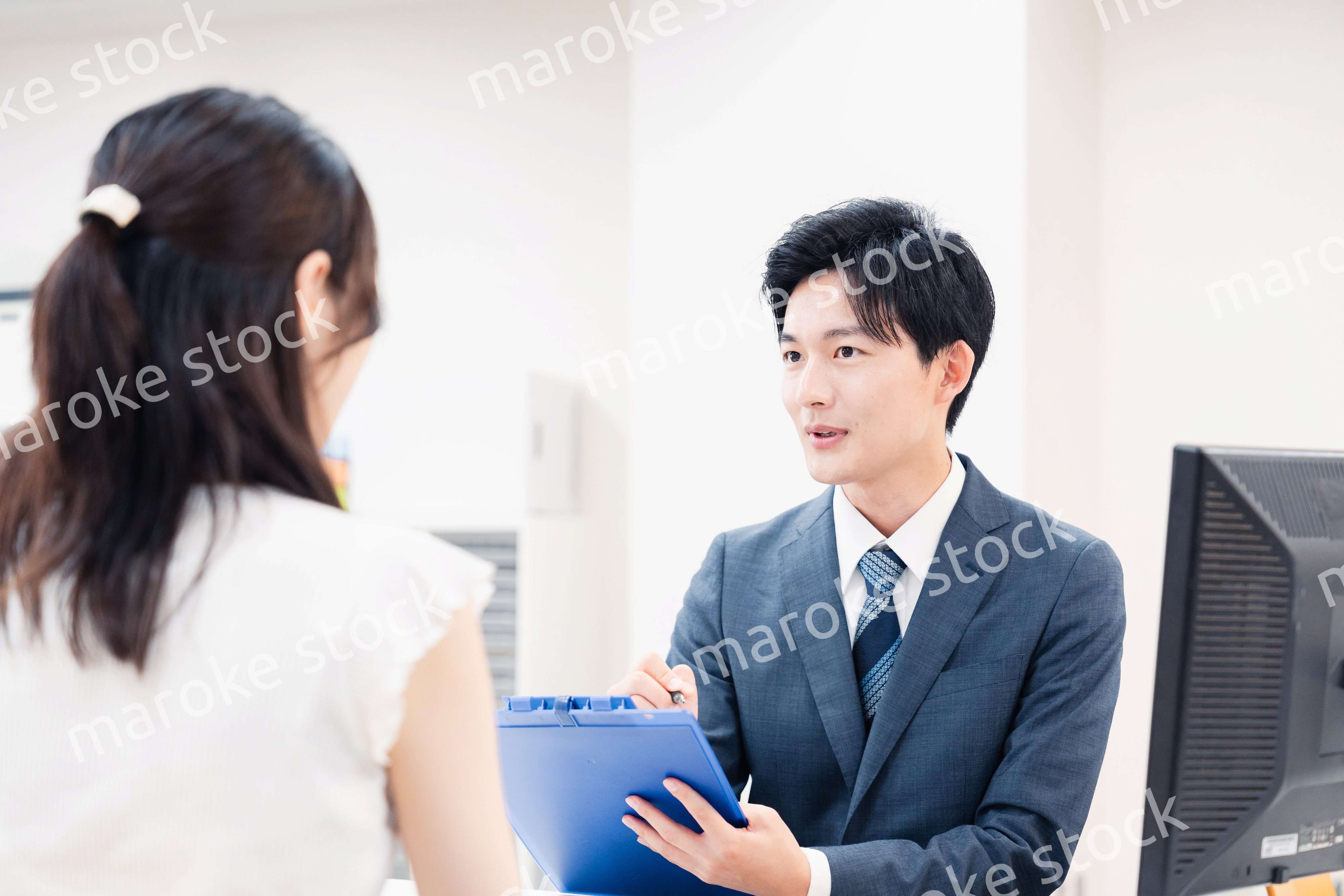 窓口で顧客の要望を聞く男性スタッフ