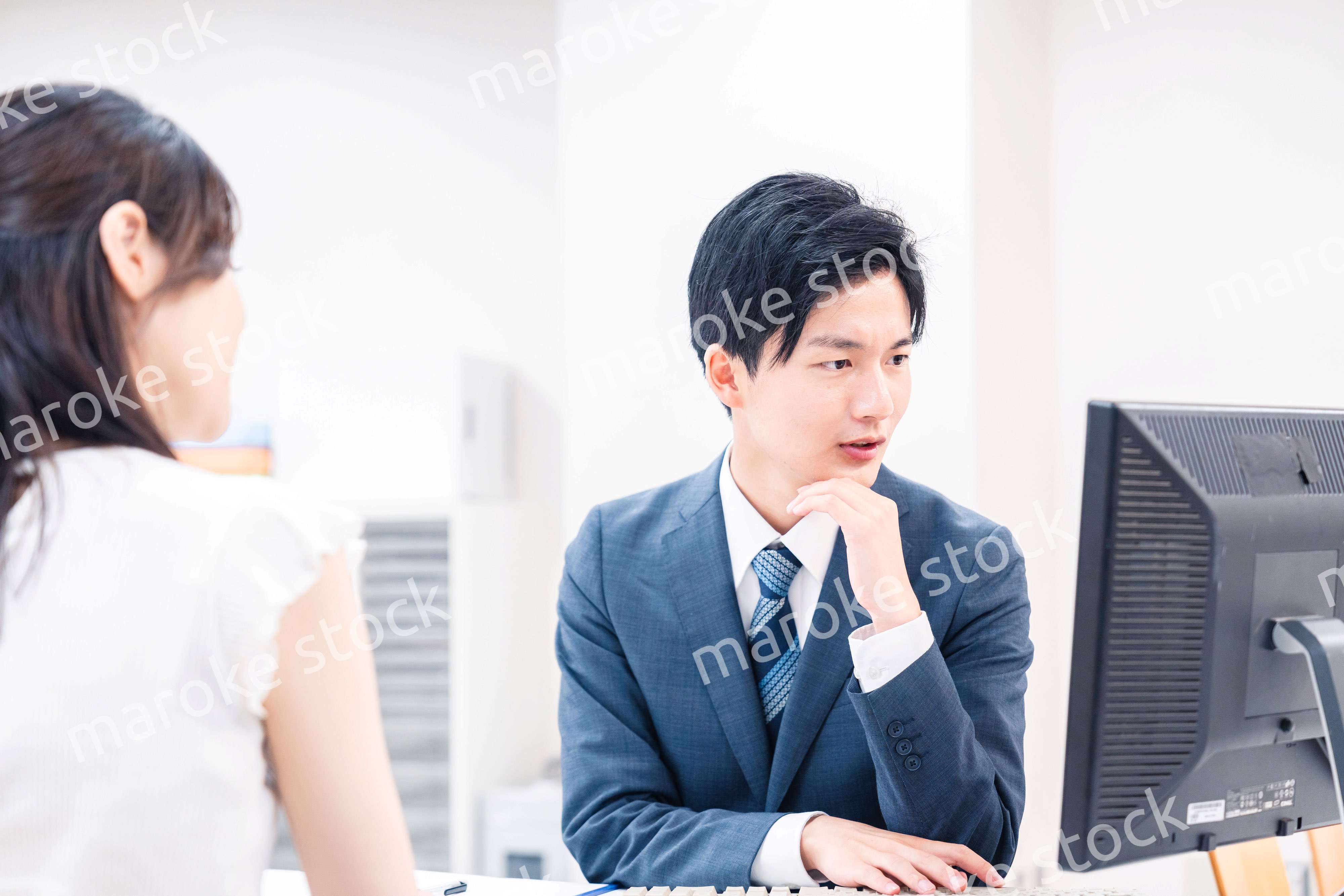 不動産会社のカウンターで相談をする若い女性