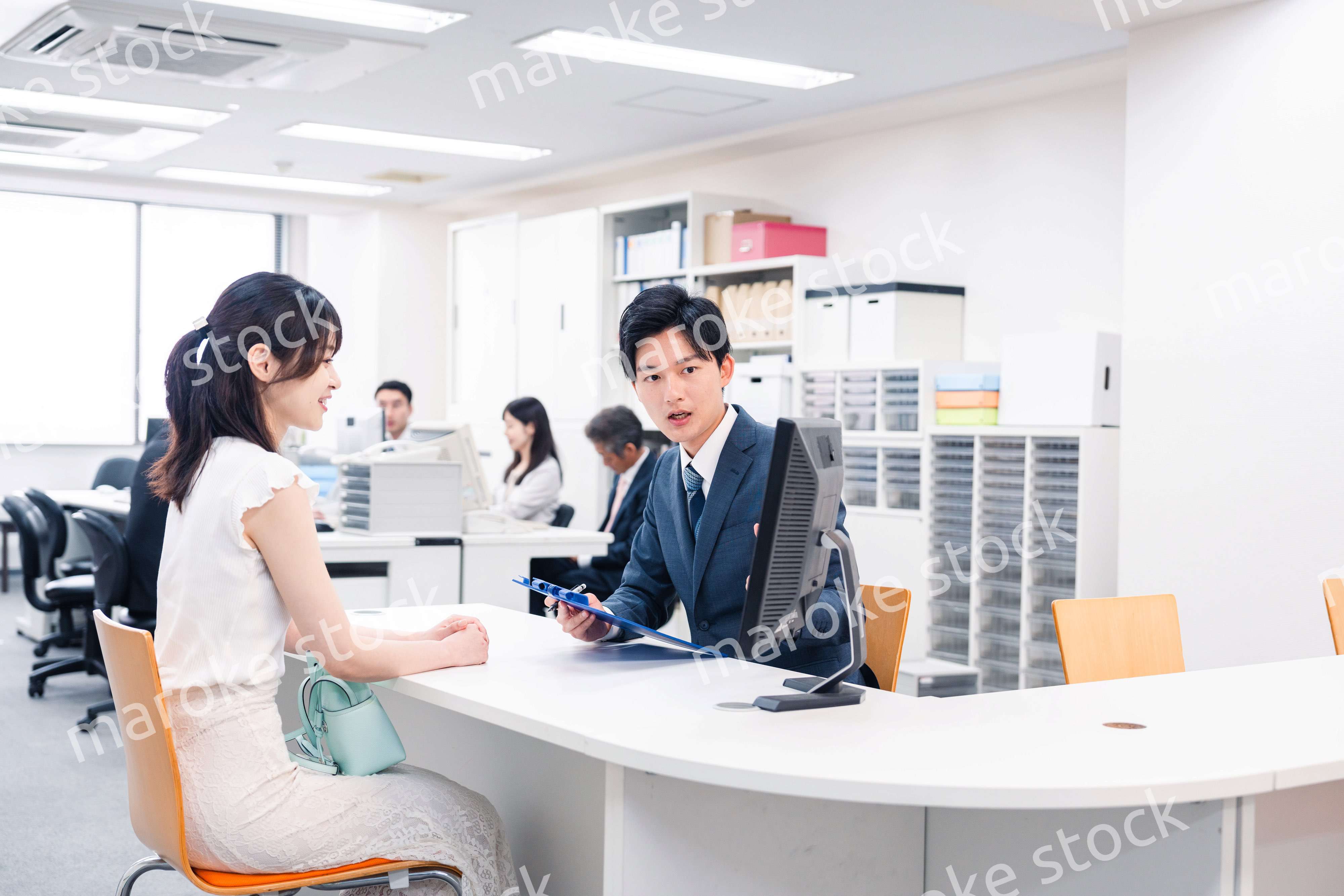 窓口で来客の対応をするビジネスパーソン