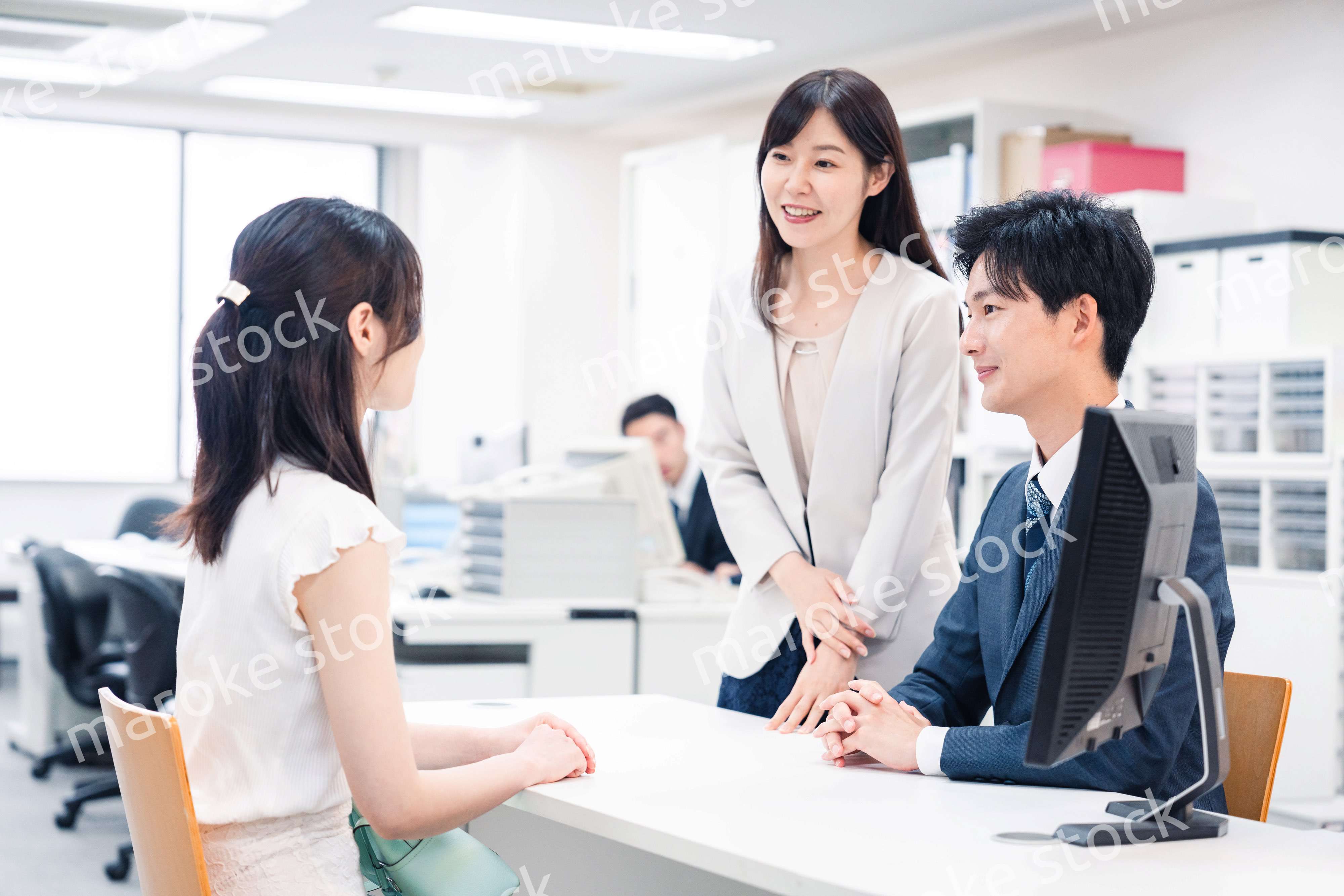 窓口で来客の対応をするビジネスパーソン