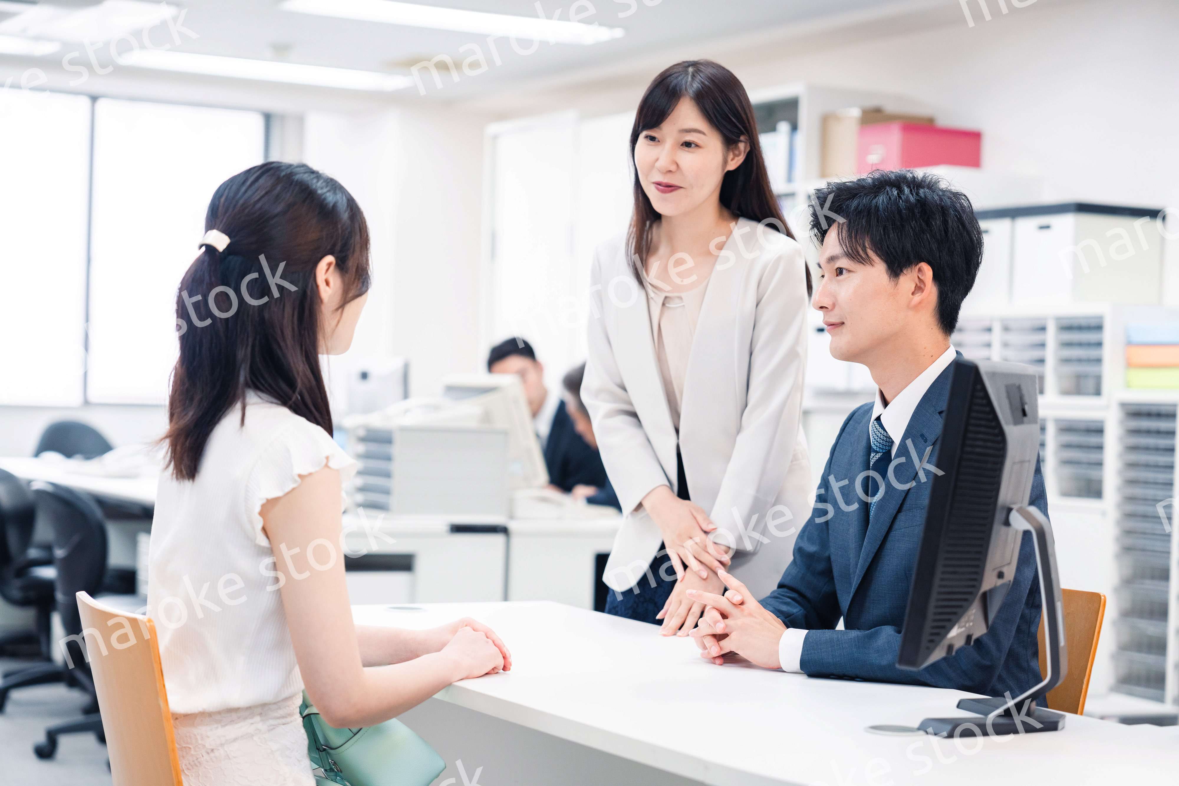 窓口で来客の対応をするビジネスパーソン
