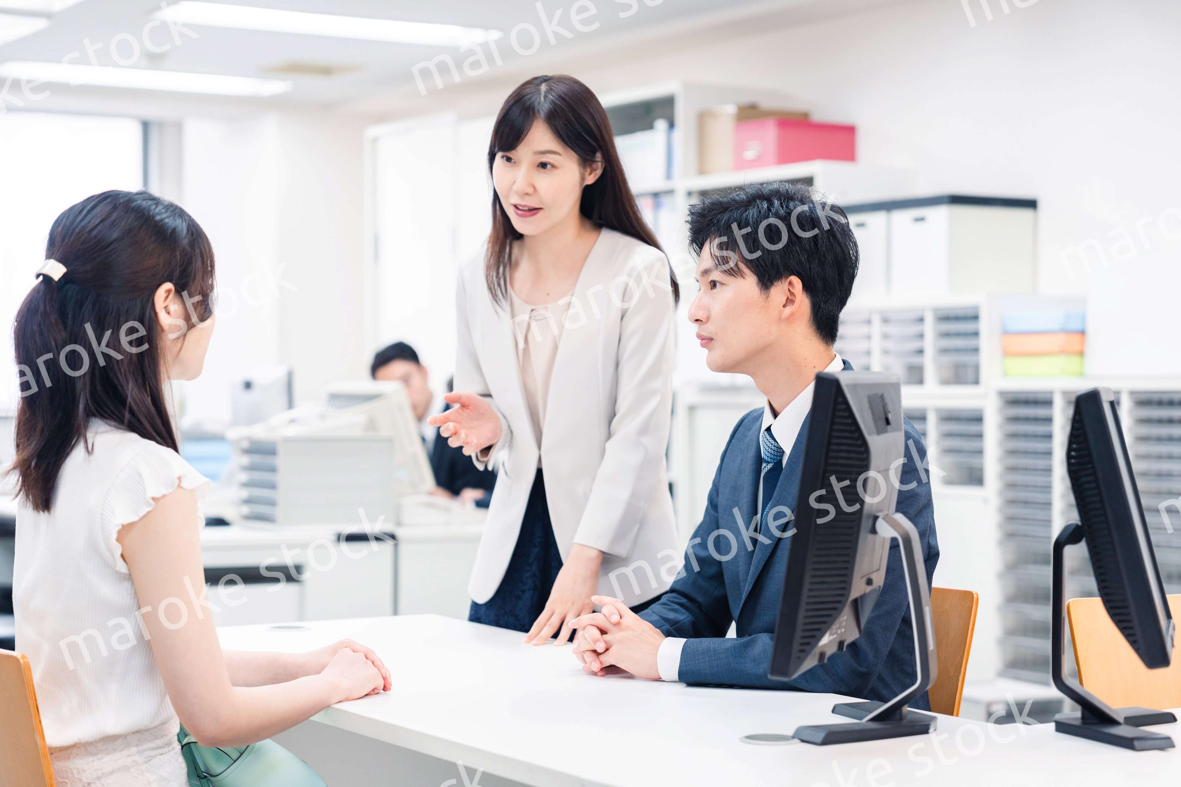 窓口で来客の対応をするビジネスパーソン