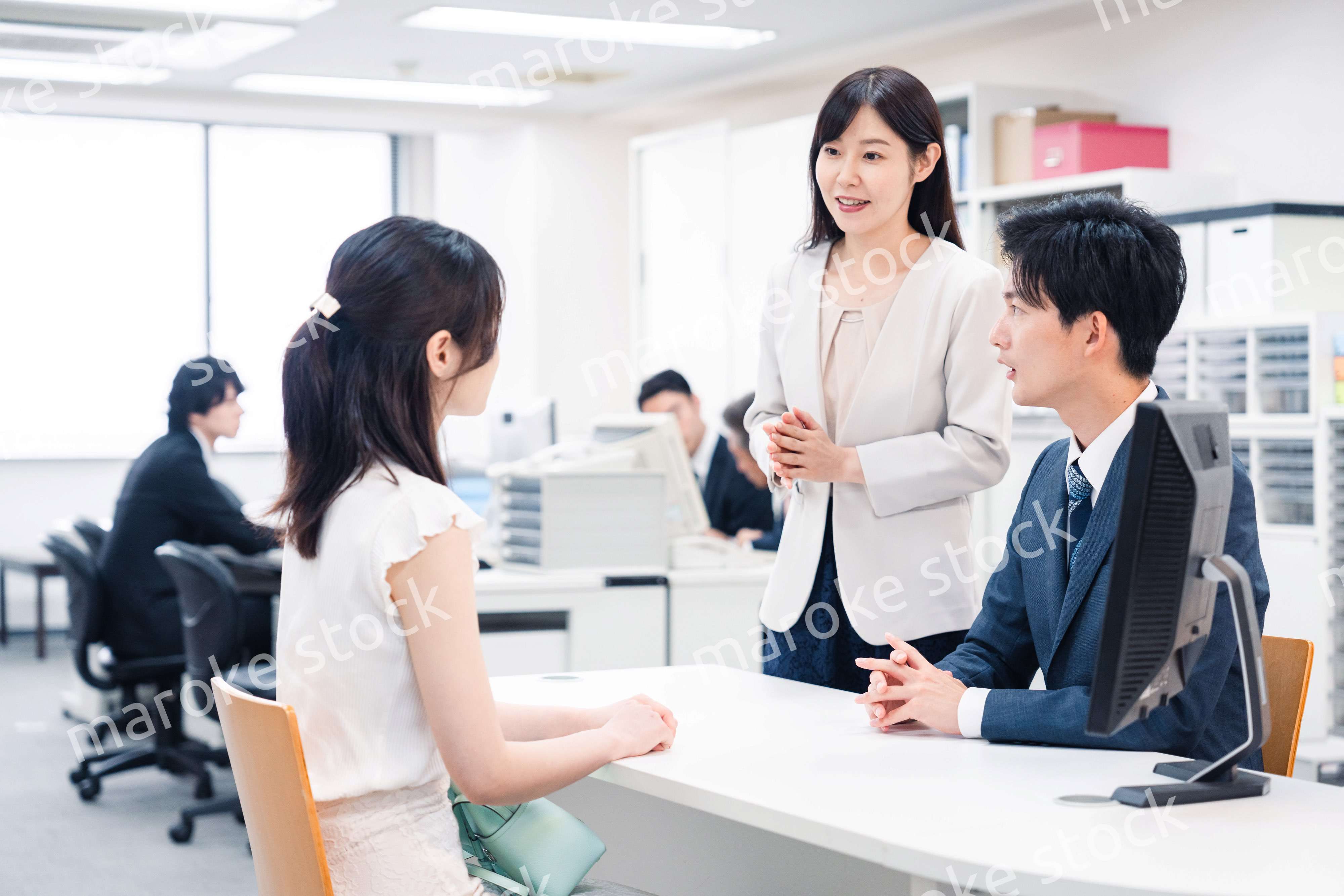 窓口で来客の対応をするビジネスパーソン