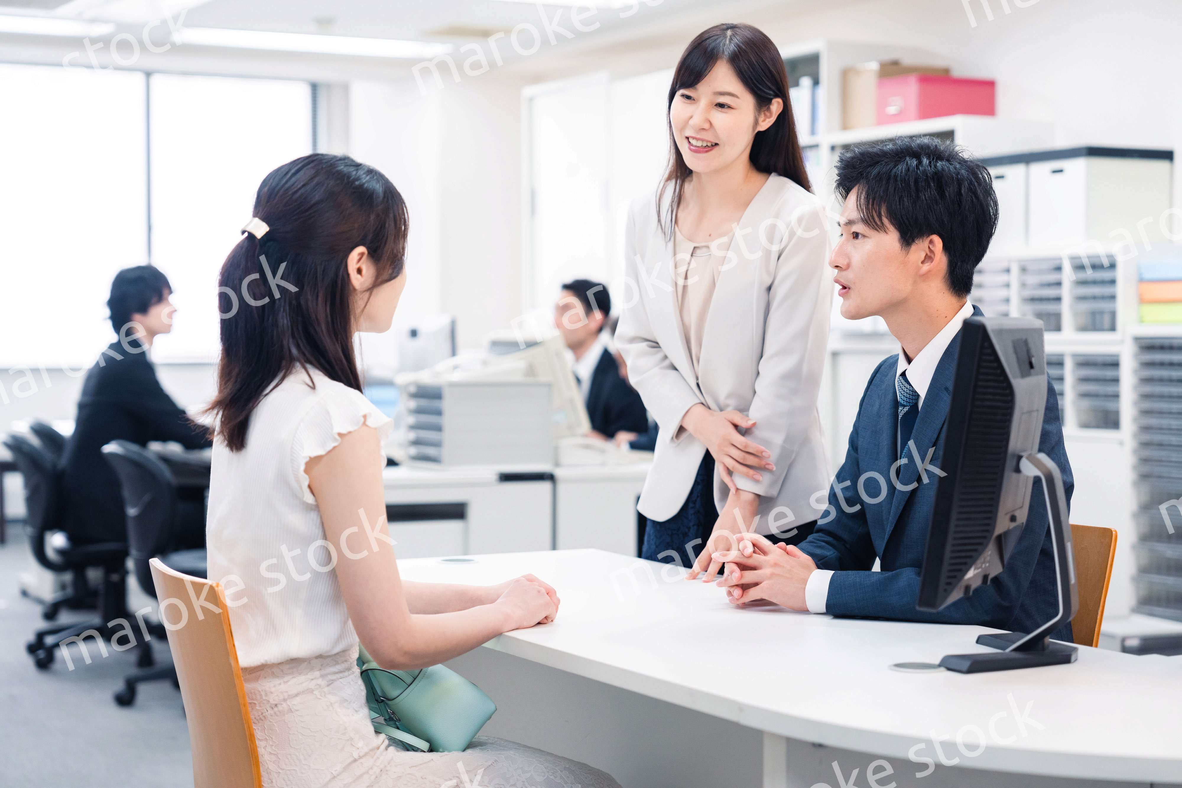 窓口で来客の対応をするビジネスパーソン