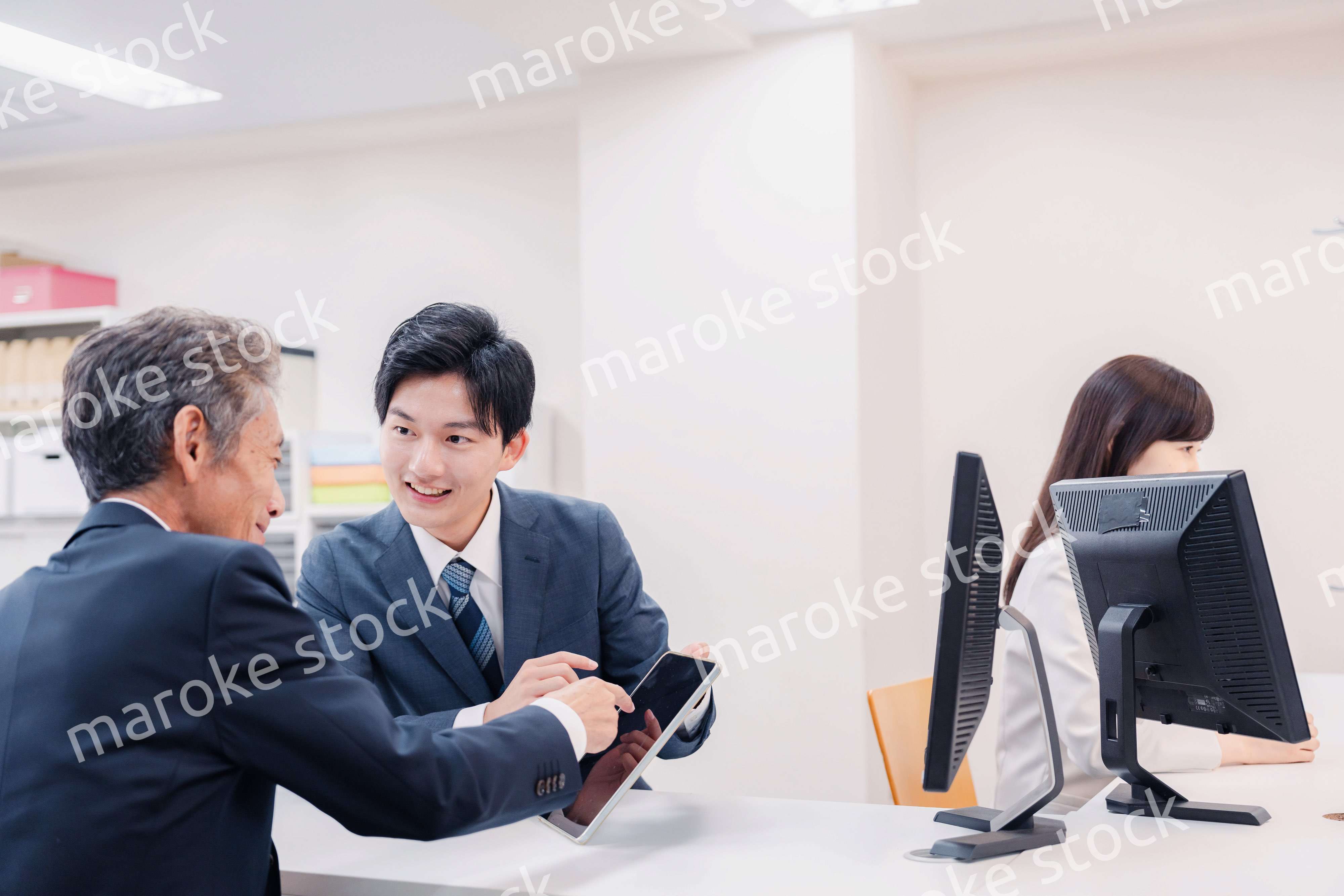 タブレットを使い窓口で接客をする男性