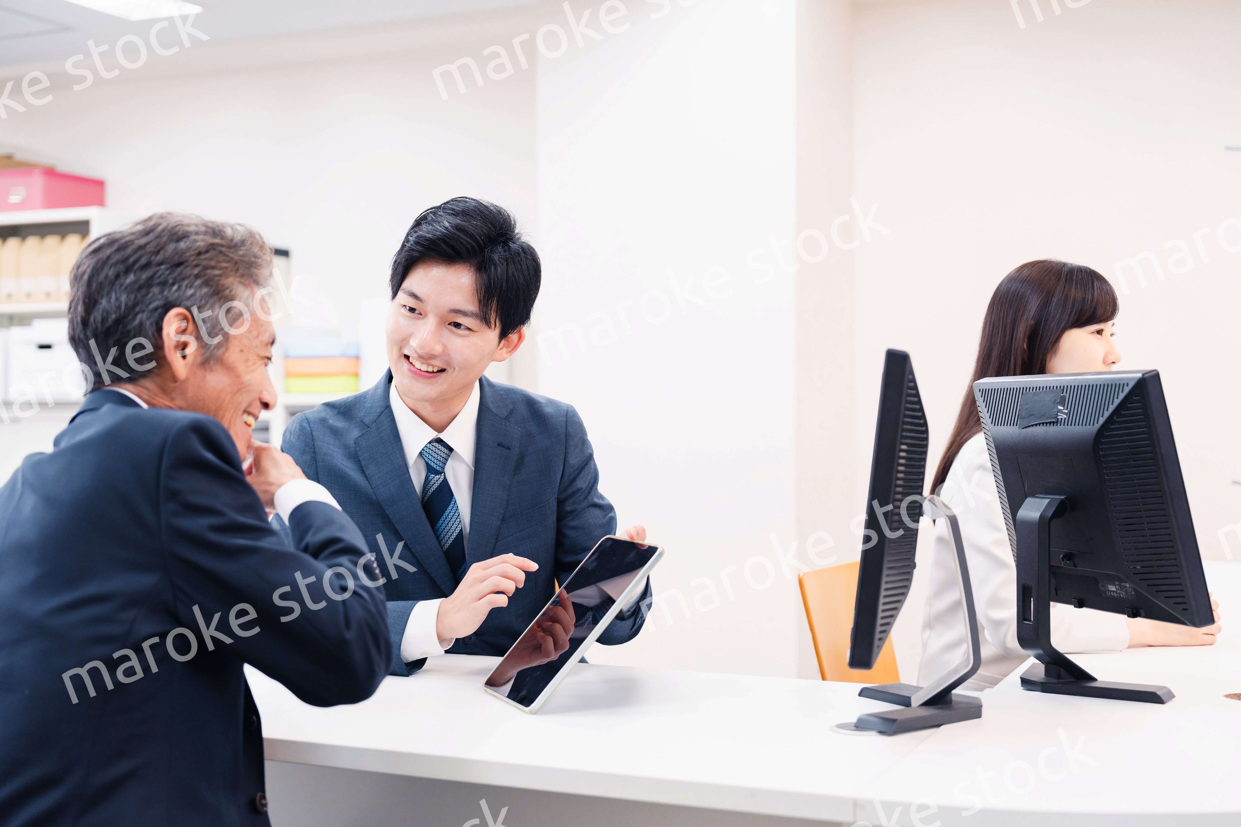 タブレットを使い窓口で接客をする男性