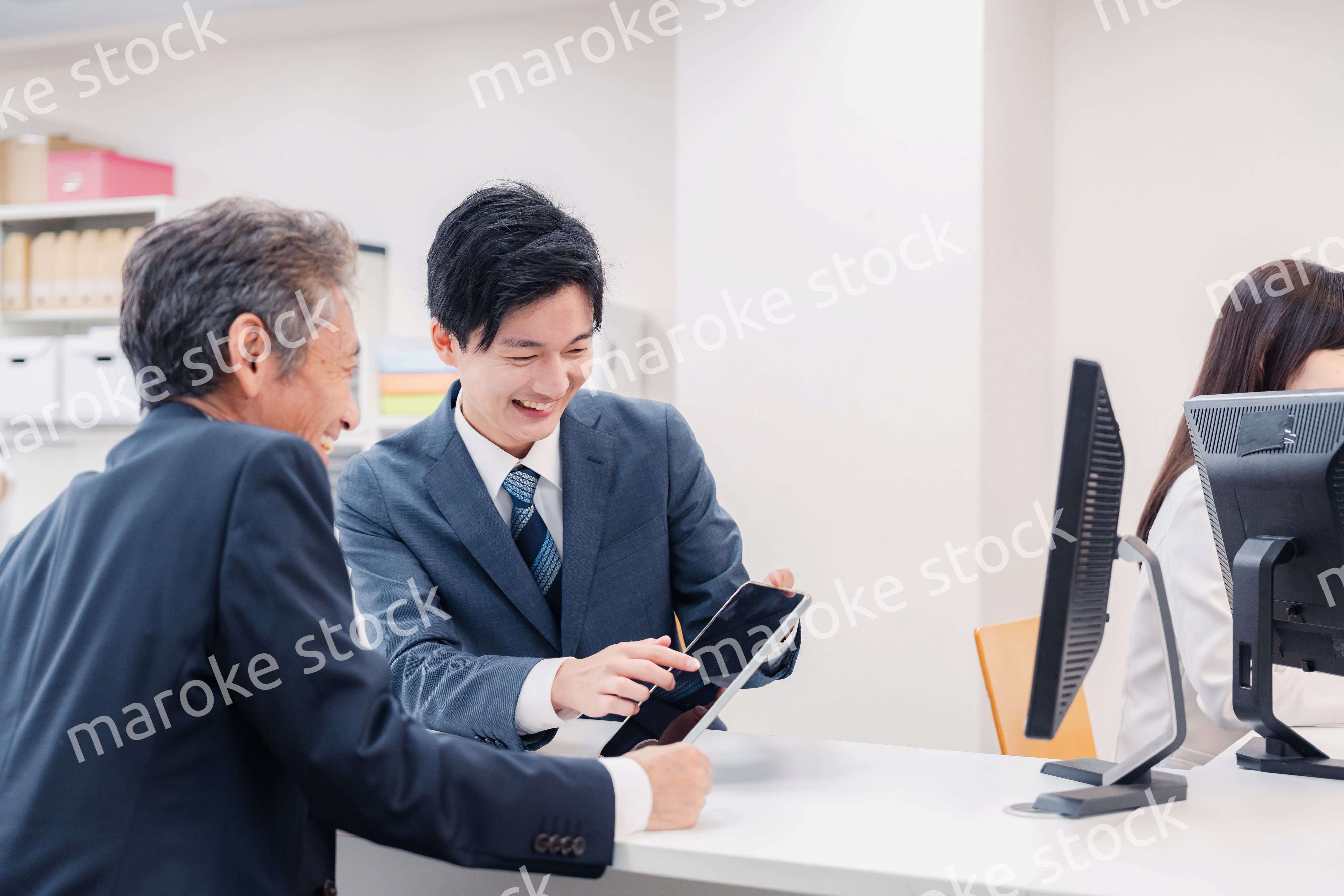 タブレットを使い窓口で接客をする男性