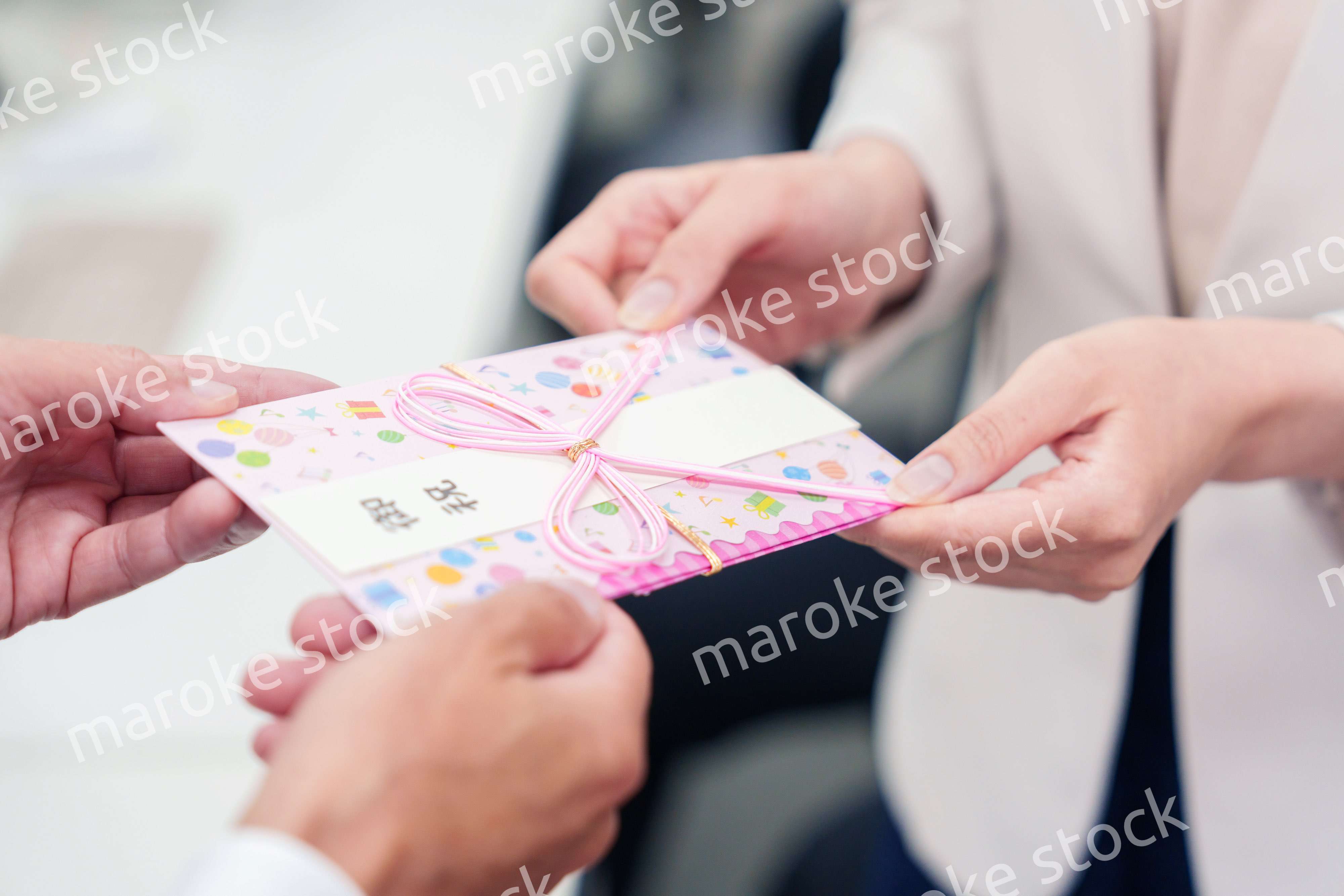 上司からお祝いを手渡されるビジネスウーマン