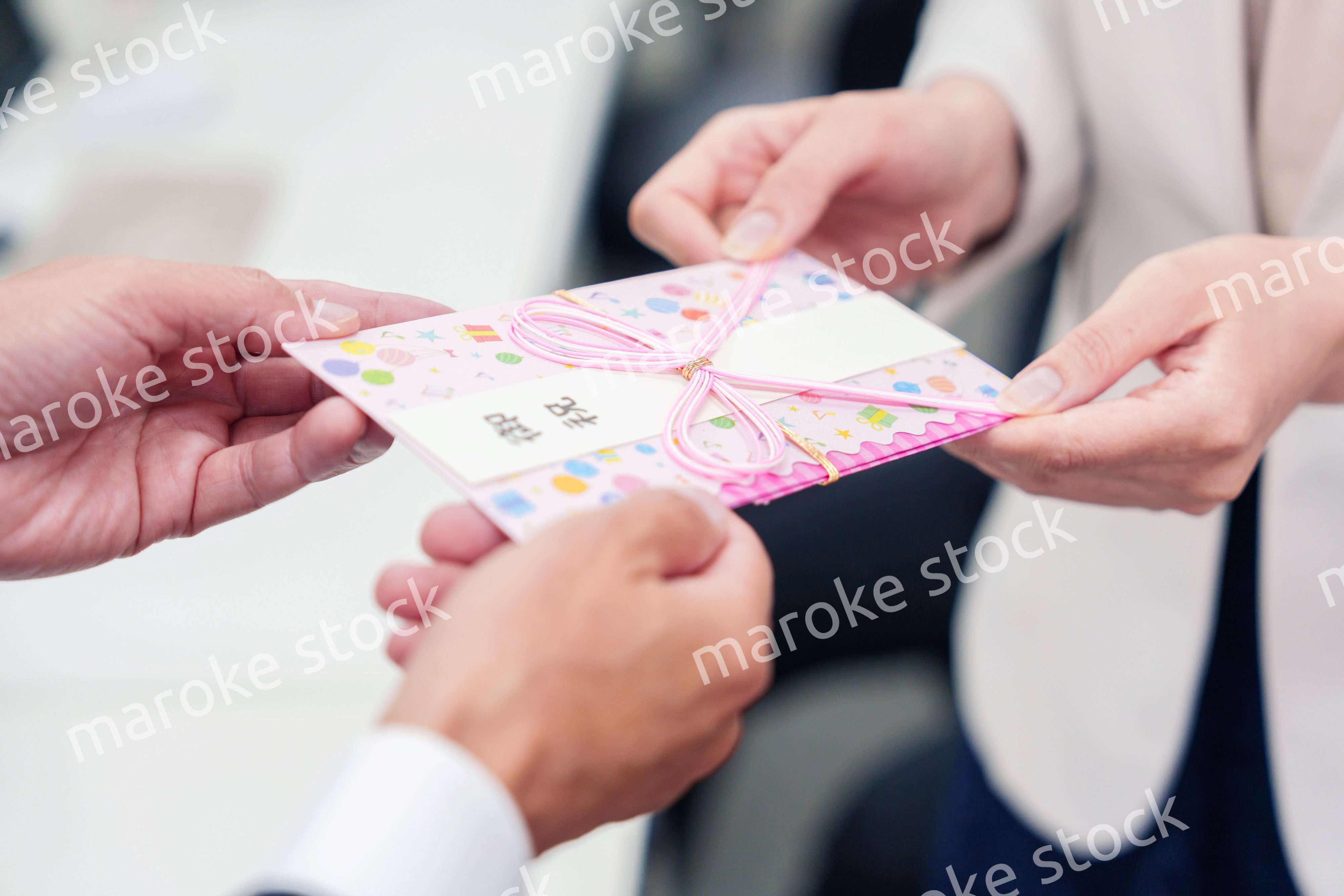 上司からお祝いを手渡されるビジネスウーマン