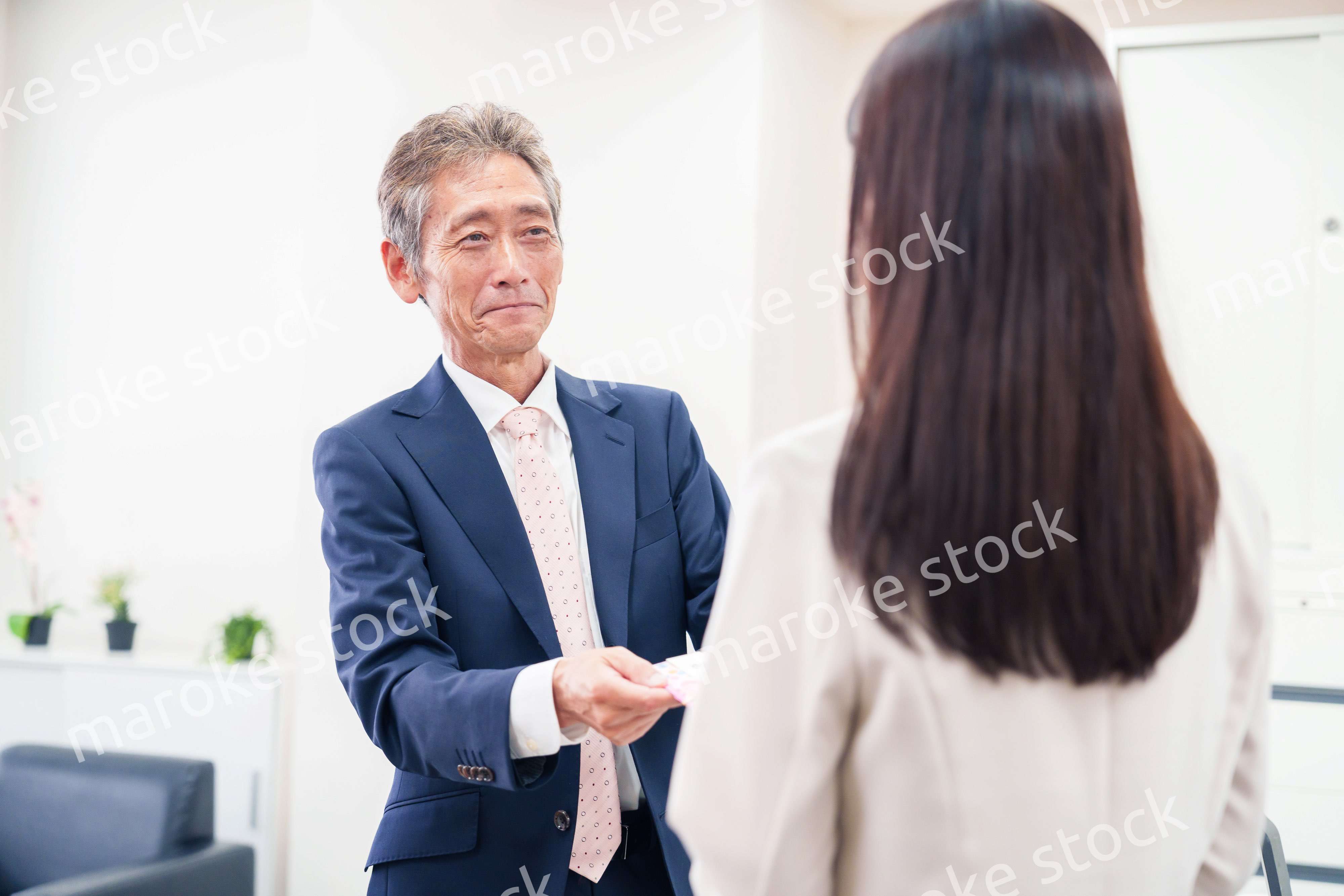 上司からお祝いを手渡されるビジネスウーマン